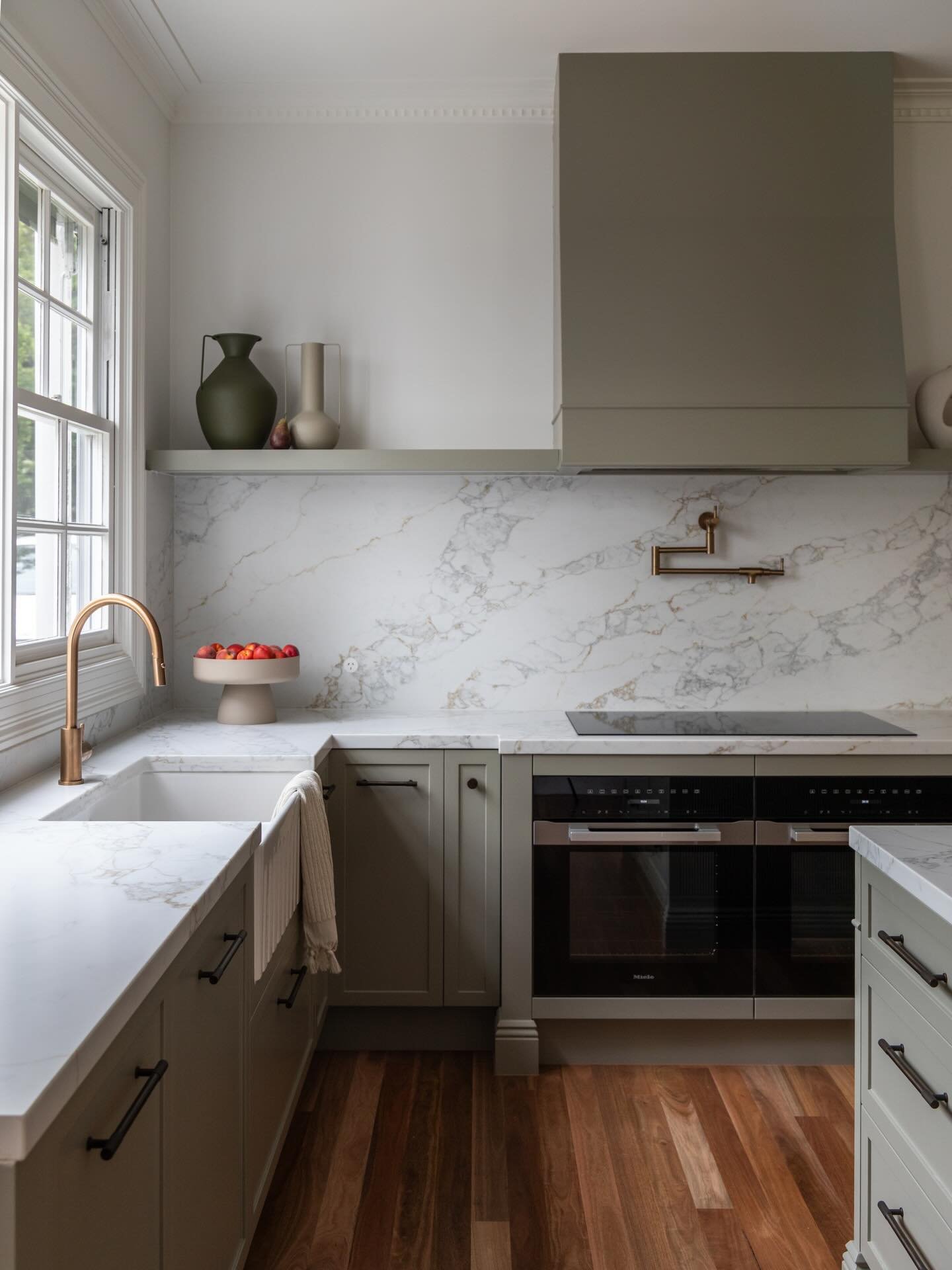 A refined blend of classic detailing and modern simplicity. This newly completed kitchen leans into a warm green palette, layered with subtle texture and soft contrast. Clean lines, traditional profiles and contemporary finishes come together for a c