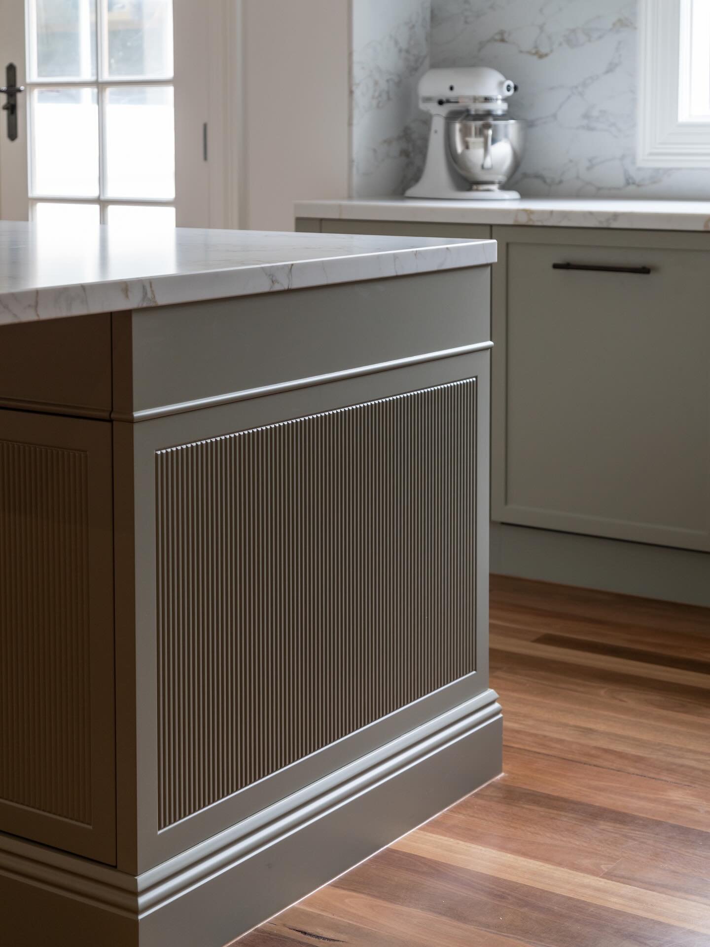The beauty is in the details.
This island is elevated through considered design choices, vertical fluting for texture and rhythm, a subtle horizontal bead to break up the mass, decorative kickboards that connect seamlessly to the room&rsquo;s skirtin