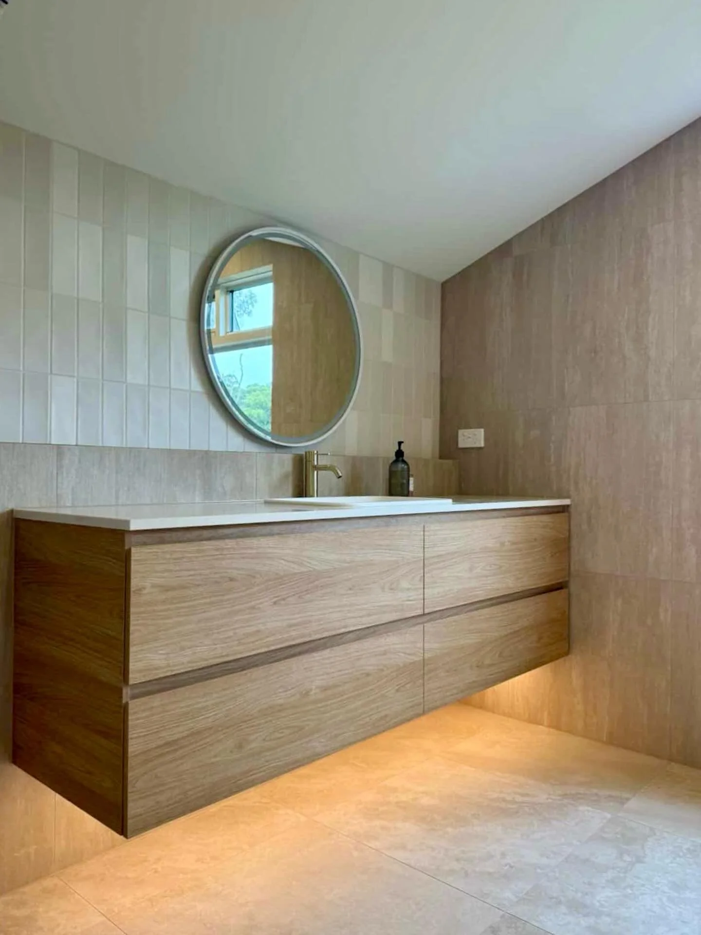 A warm neutral palette sets the tone for this bathroom, creating a space that feels calm, soft, and inviting. 

Natural textures add depth, while the vanity anchors the room with clean lines and a simple, considered presence. 

A restrained material 