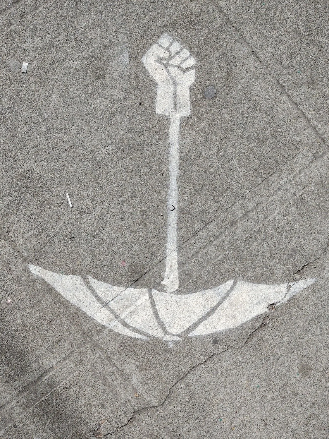 A stencil of an umbrella with fist handle on the sidewalk in Capitol Hill, Seattle, in June 2020