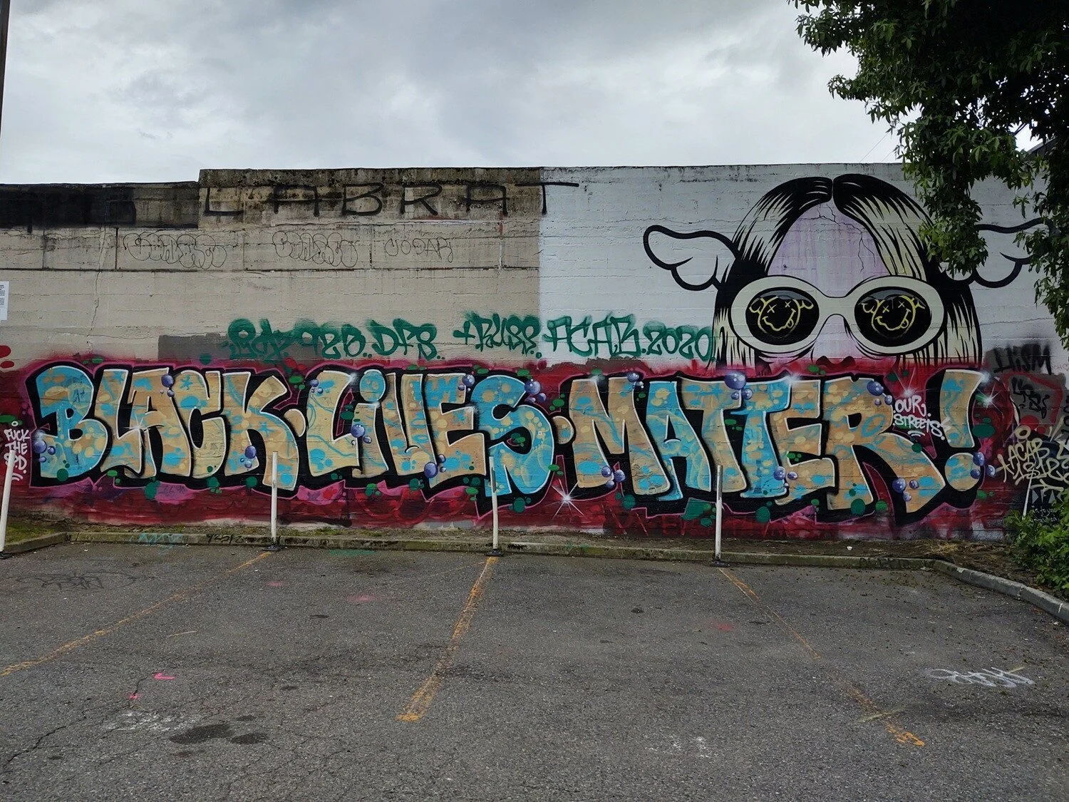 “Black Lives Matter” in multi-color letters against a red background. Kurt Cobain’s peeks over the word “Matter.”