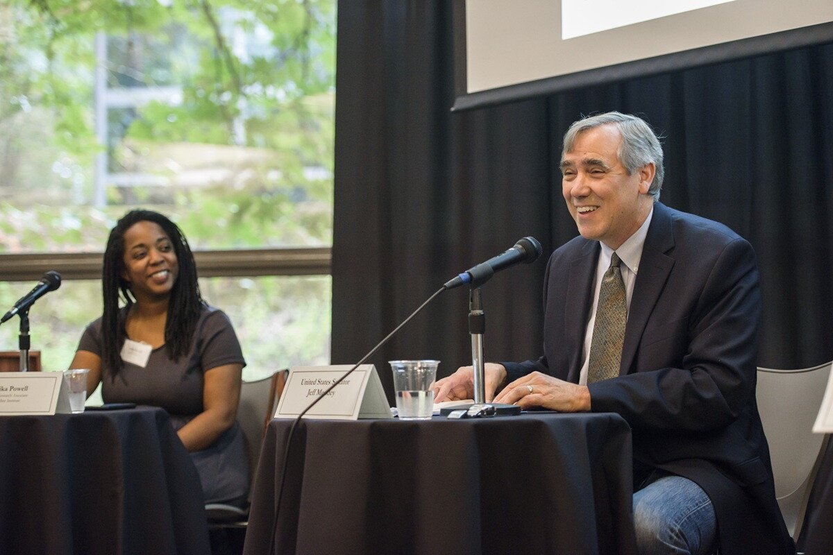 Tarika Powell looks on as Senator Jeff Merkley speaks about the future of green energy.