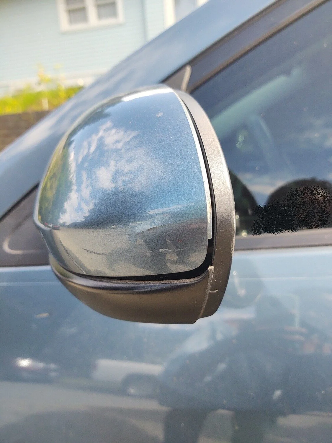 There are several gaps between the front and back panels of the rearview mirror and a scratch on the back panel.