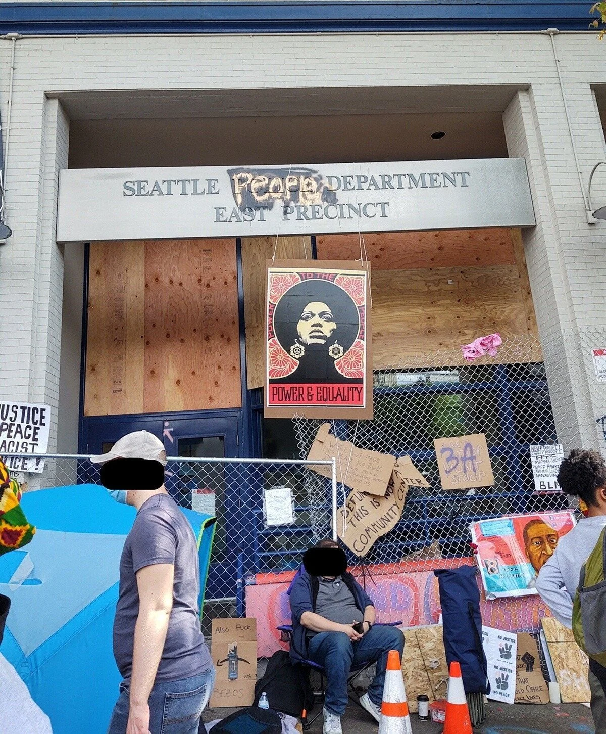 Signage on the precinct has been changed to read “Seattle People’s Department.” A poster shows a Black woman with afro.