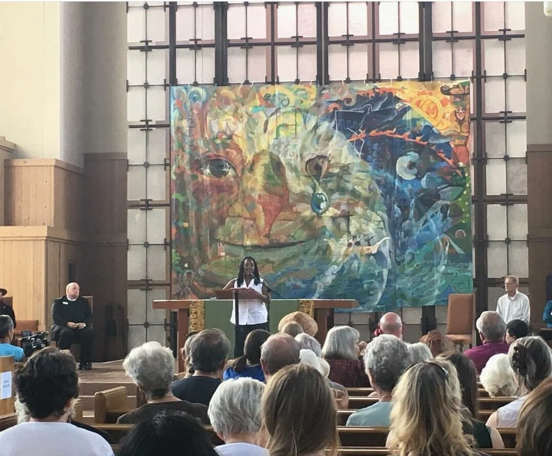 Tarika Powell speaks at Lummi Totem Pole Journey stop in Seattle in 2016 as other speakers look on.