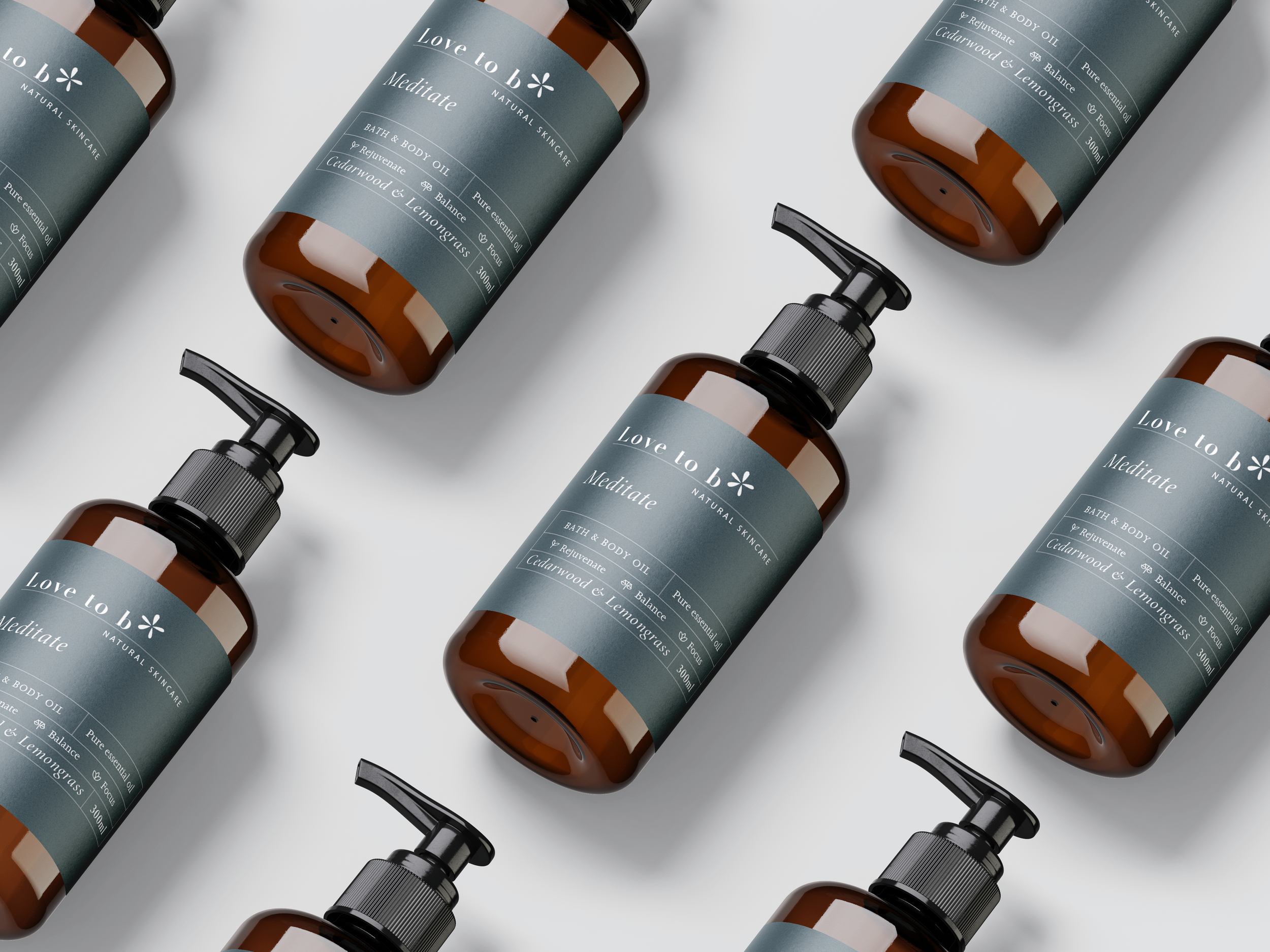 Multiple amber-colored bottles of Love to be natural skincare bath and body oil with gray and white labels on a white background.