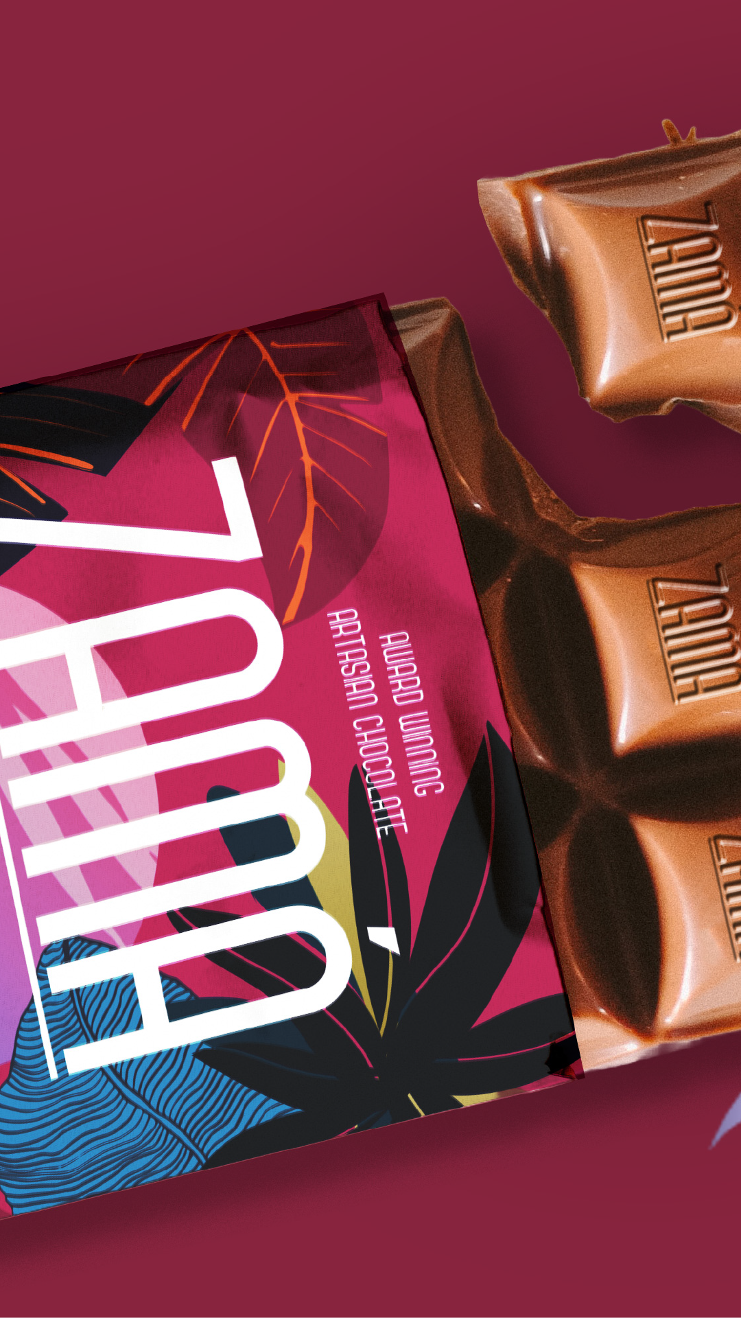 A box of Ghirardelli chocolate squares with a colorful, abstract design and a magazine or booklet with the word "TRIBE" in large white letters on a pink and purple background.