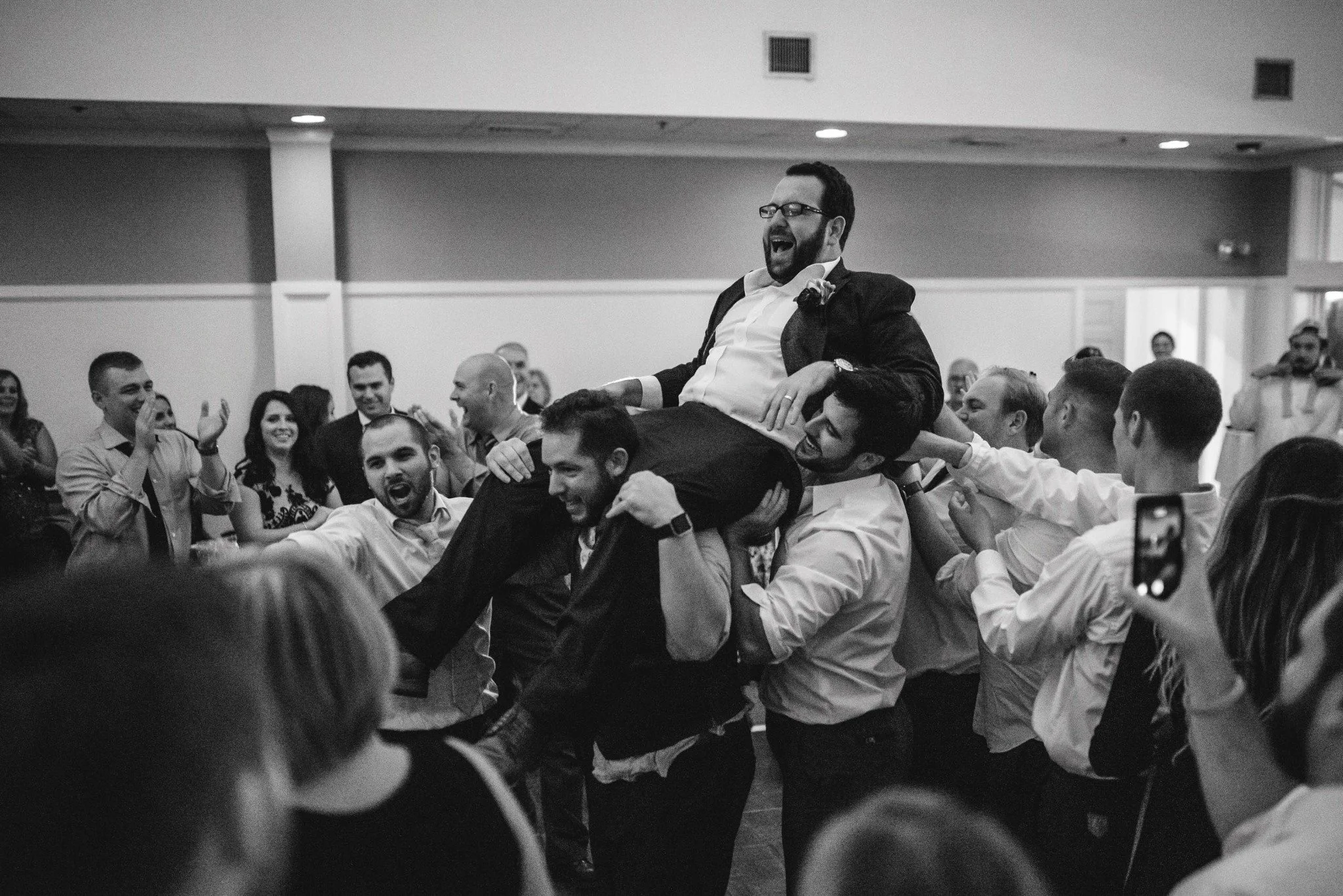 new-england-wedding-photographer-reception-dance-floor-groom-lifted-by-friends-celebration-006.jpg