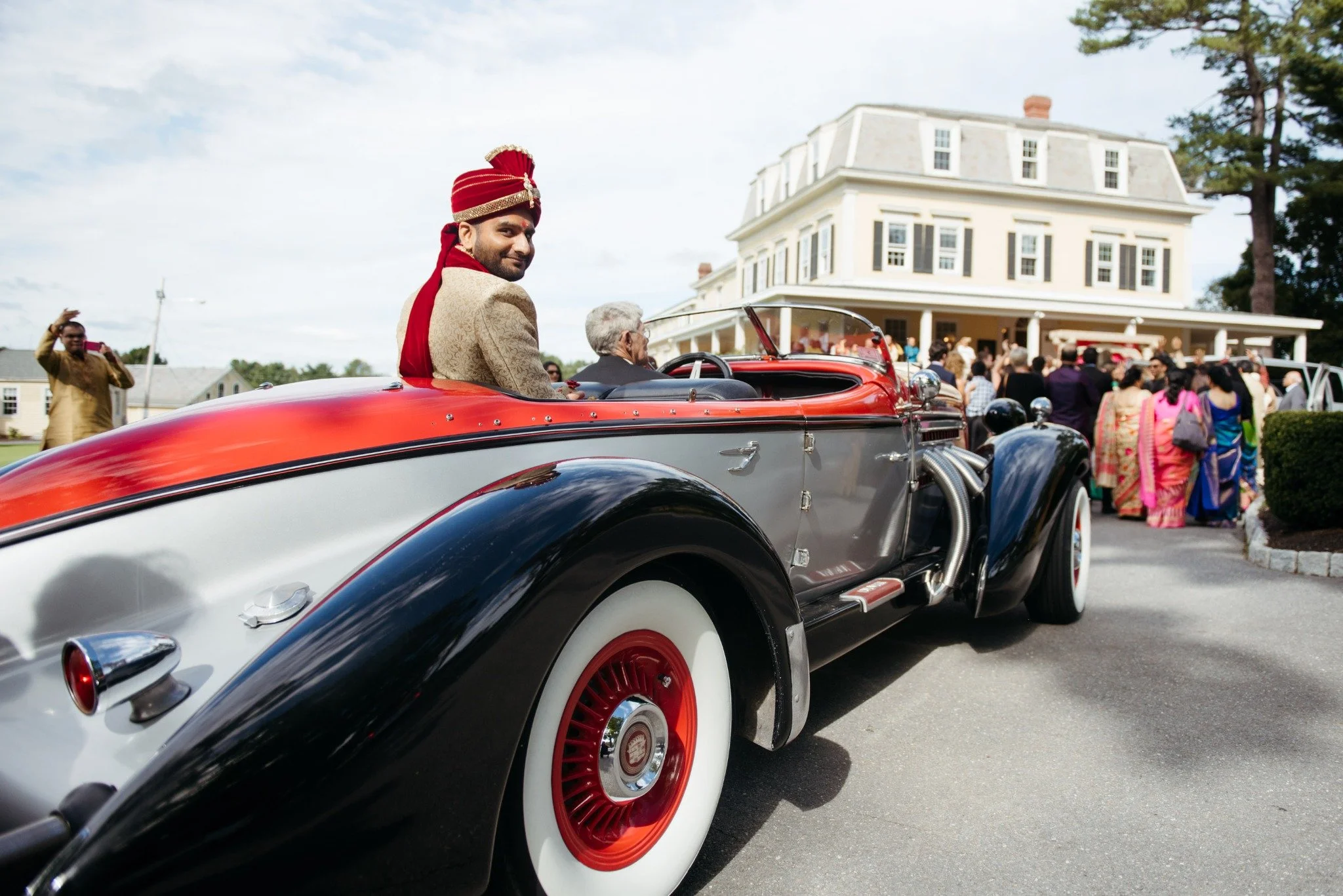 massachusetts-wedding-photographer-baraat-groom-arriving-in-vintage-convertible-011.jpg