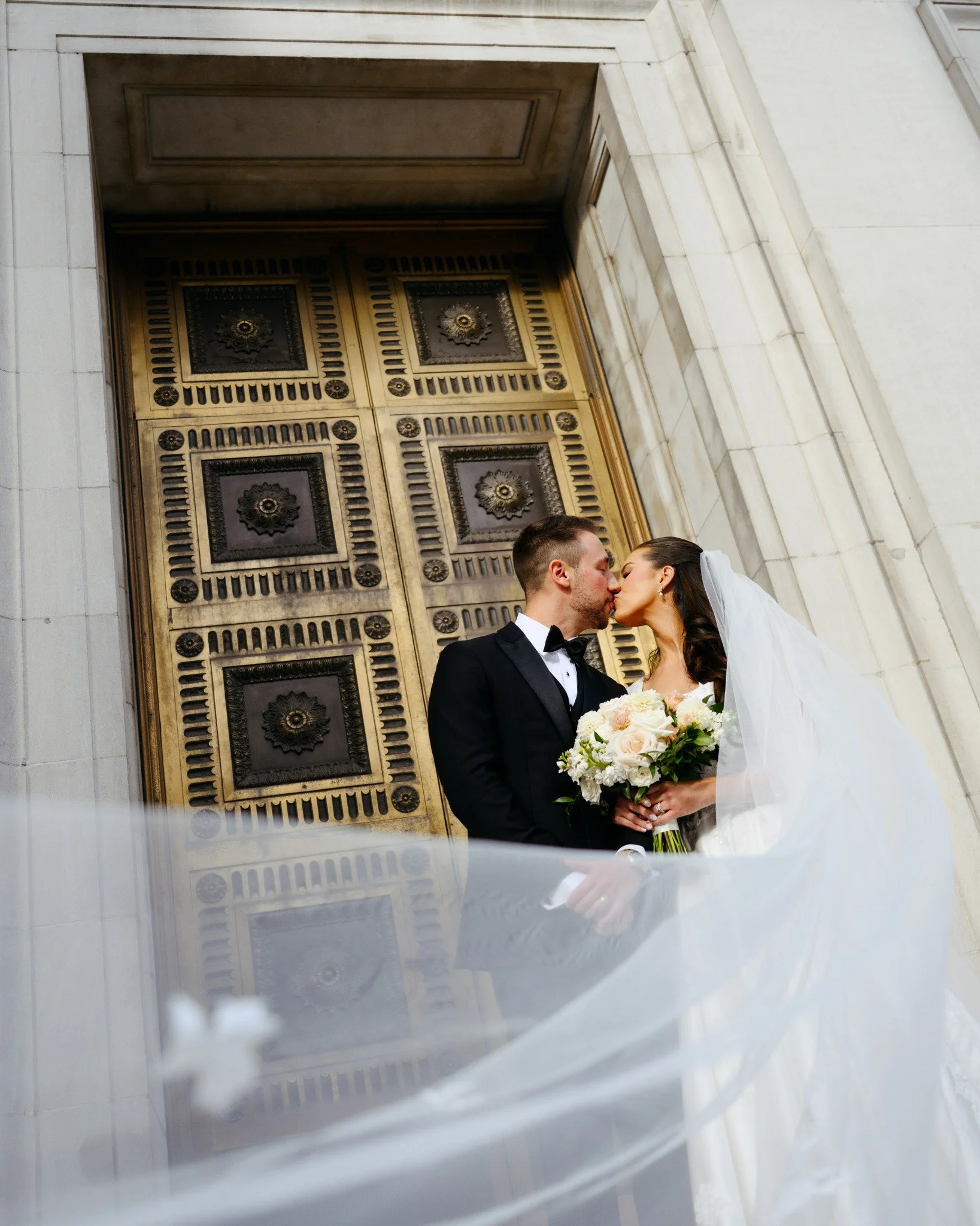 boston-wedding-photographer-couple-kissing-in-front-of-gold-doors-veil-motion-048.jpg