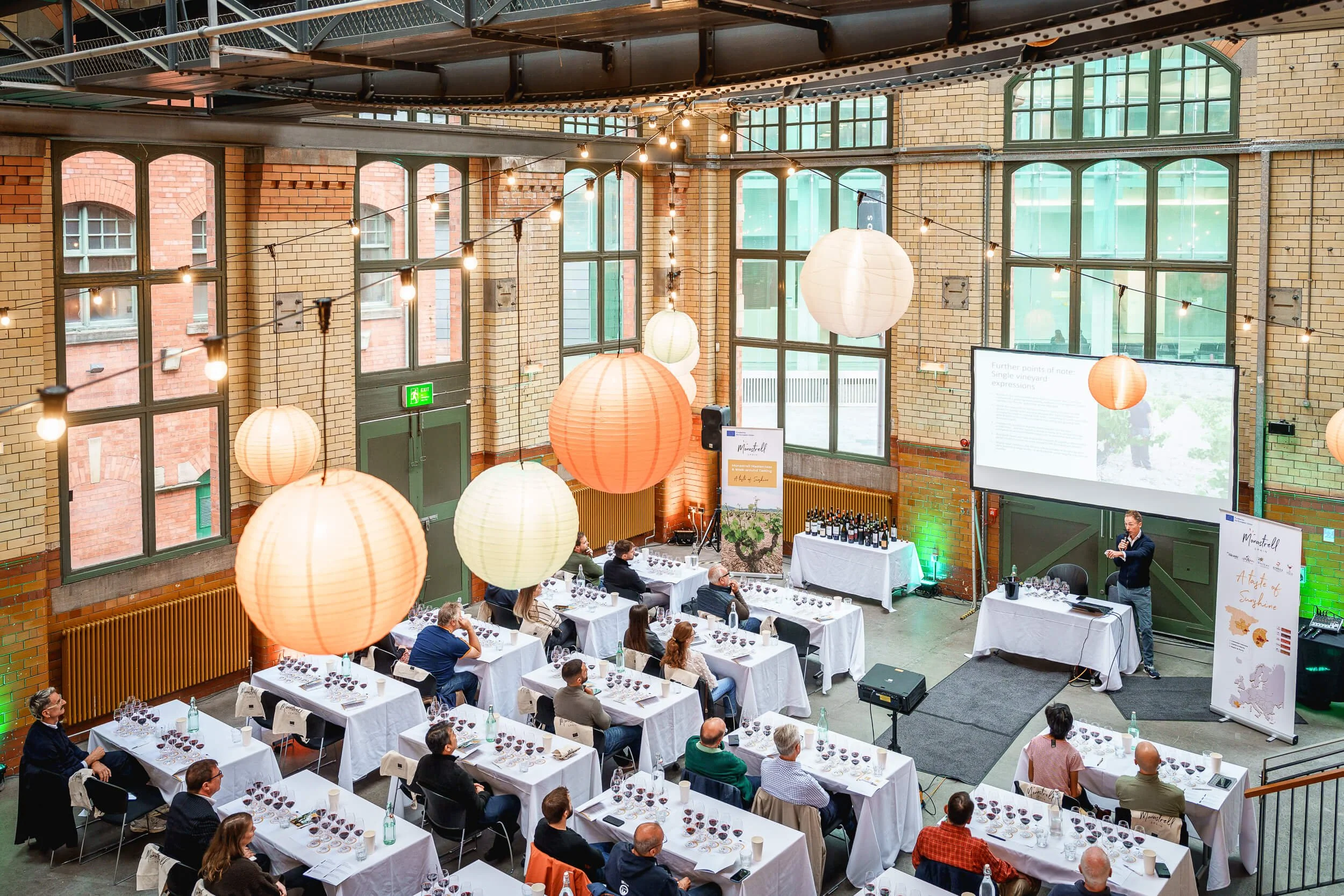 Wide view of tables and guests at a professional networking and tasting event.