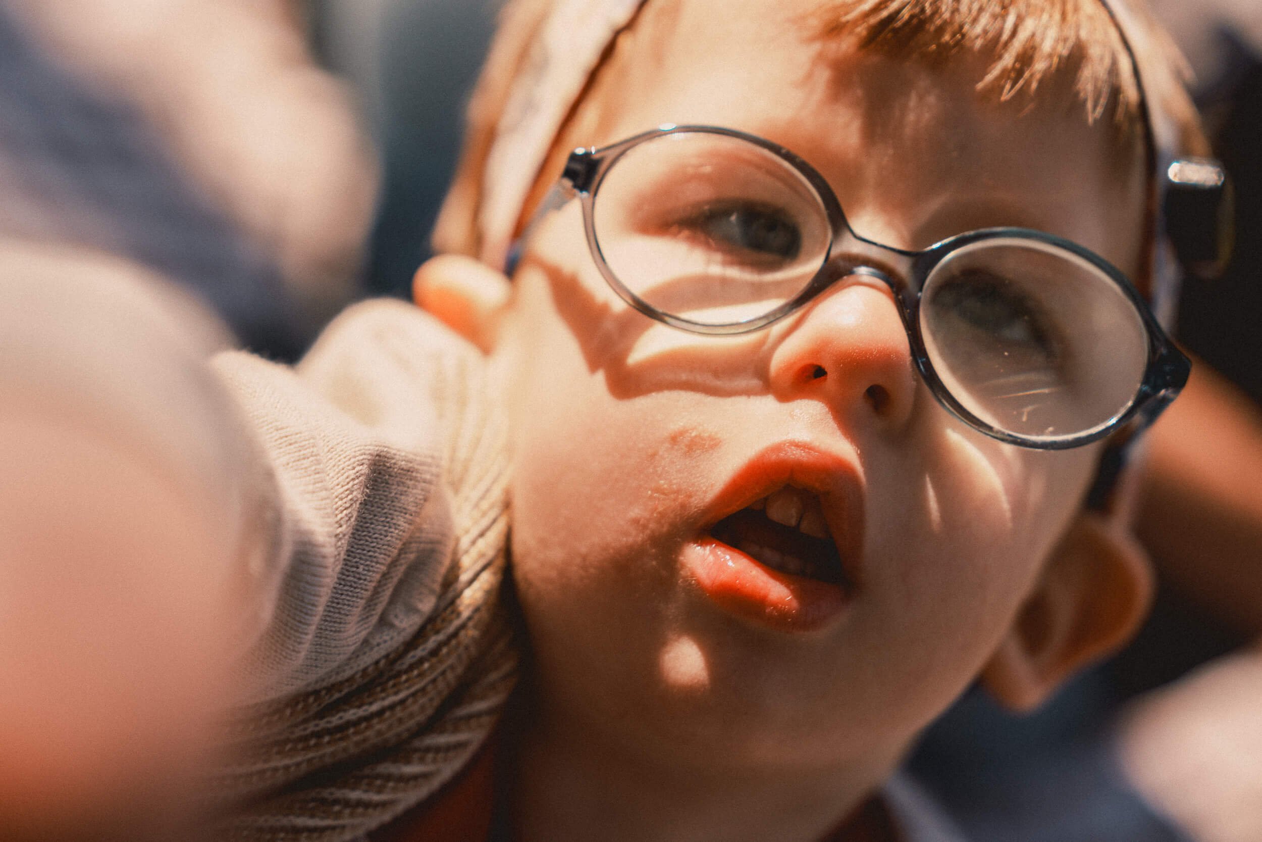 Candid close-up of a child reaching towards the camera during the Muscular Dystrophy UK shoot.