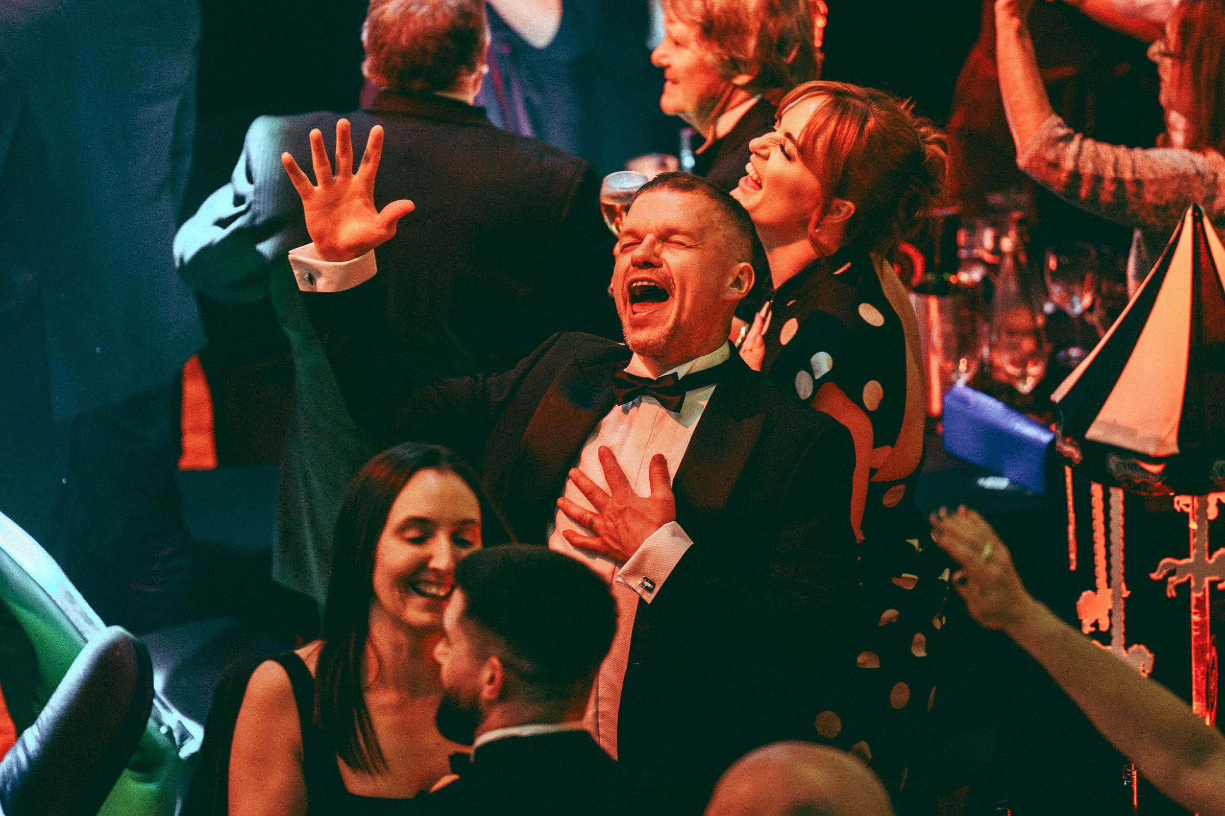 Guests celebrating and raising their hands during an awards ceremony.