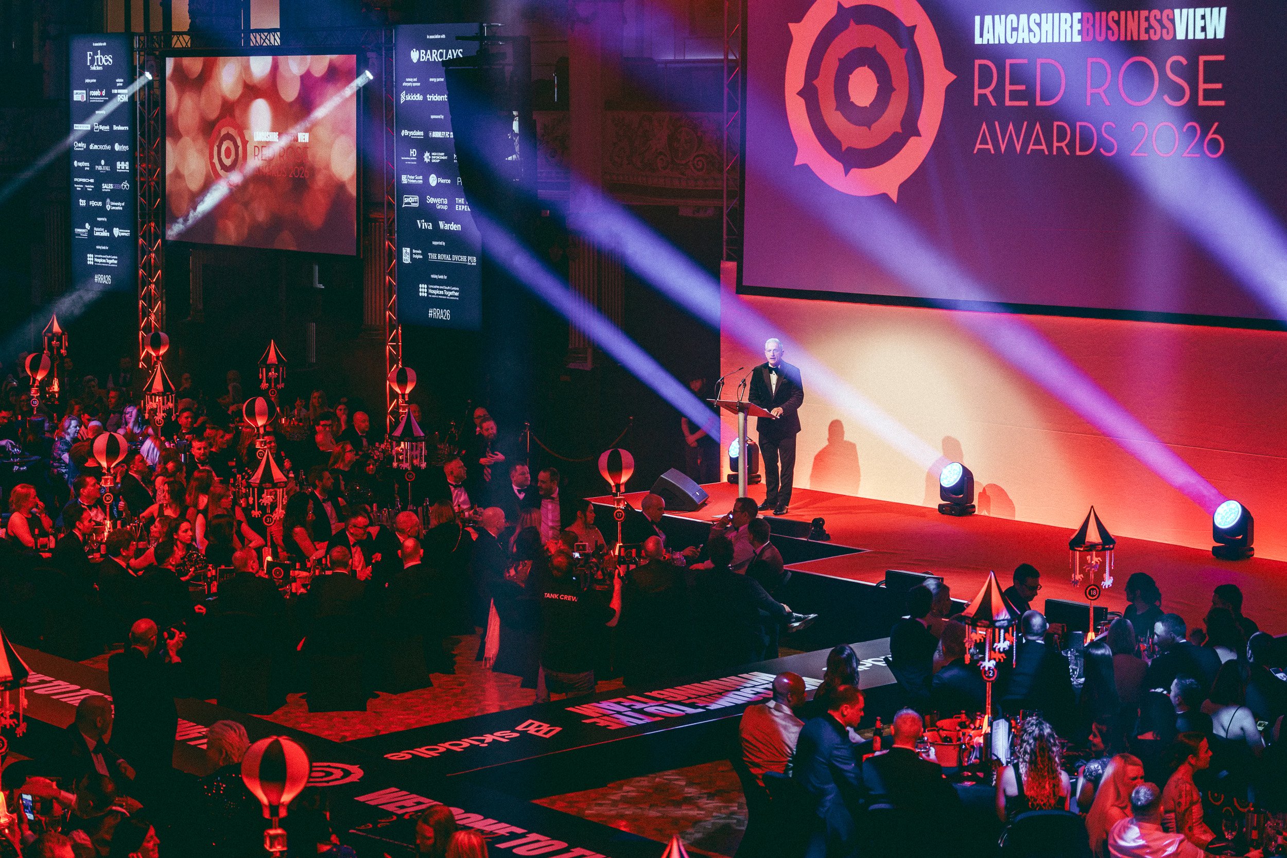 Large audience watching an awards ceremony from the event floor.