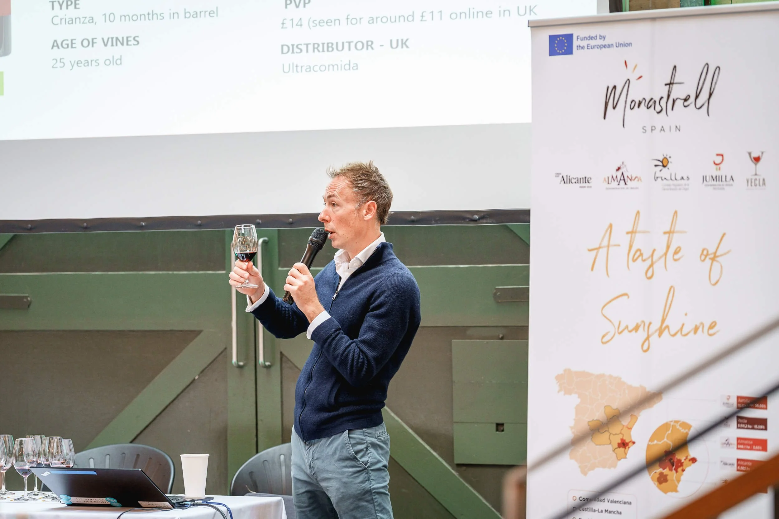 Wine professional presenting a bottle during a B2B tasting event.