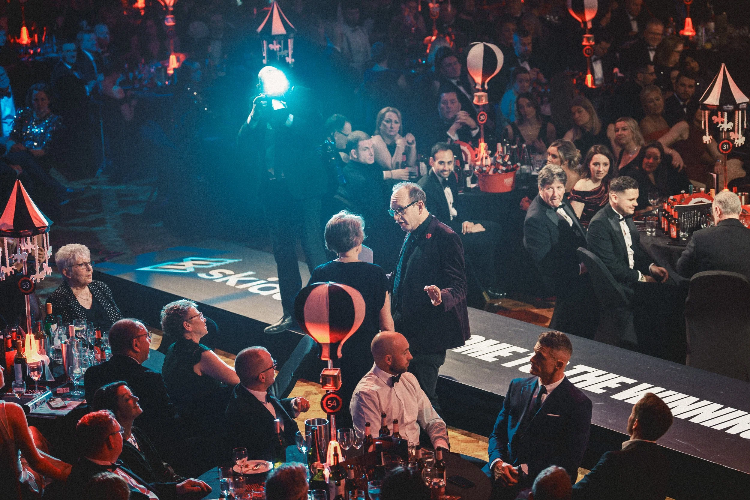 Guests watching a live performance on stage during an awards ceremony.