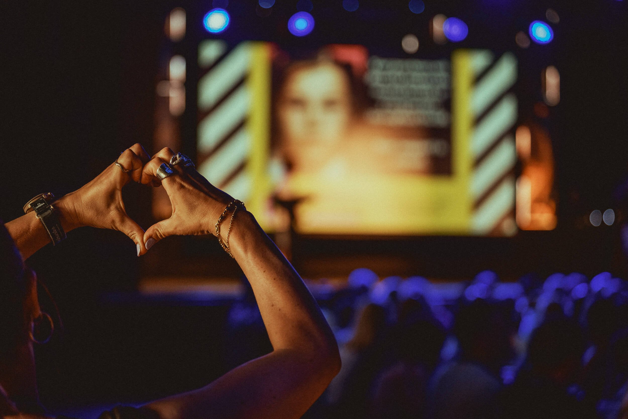 Audience member photographing the stage during an evening event.