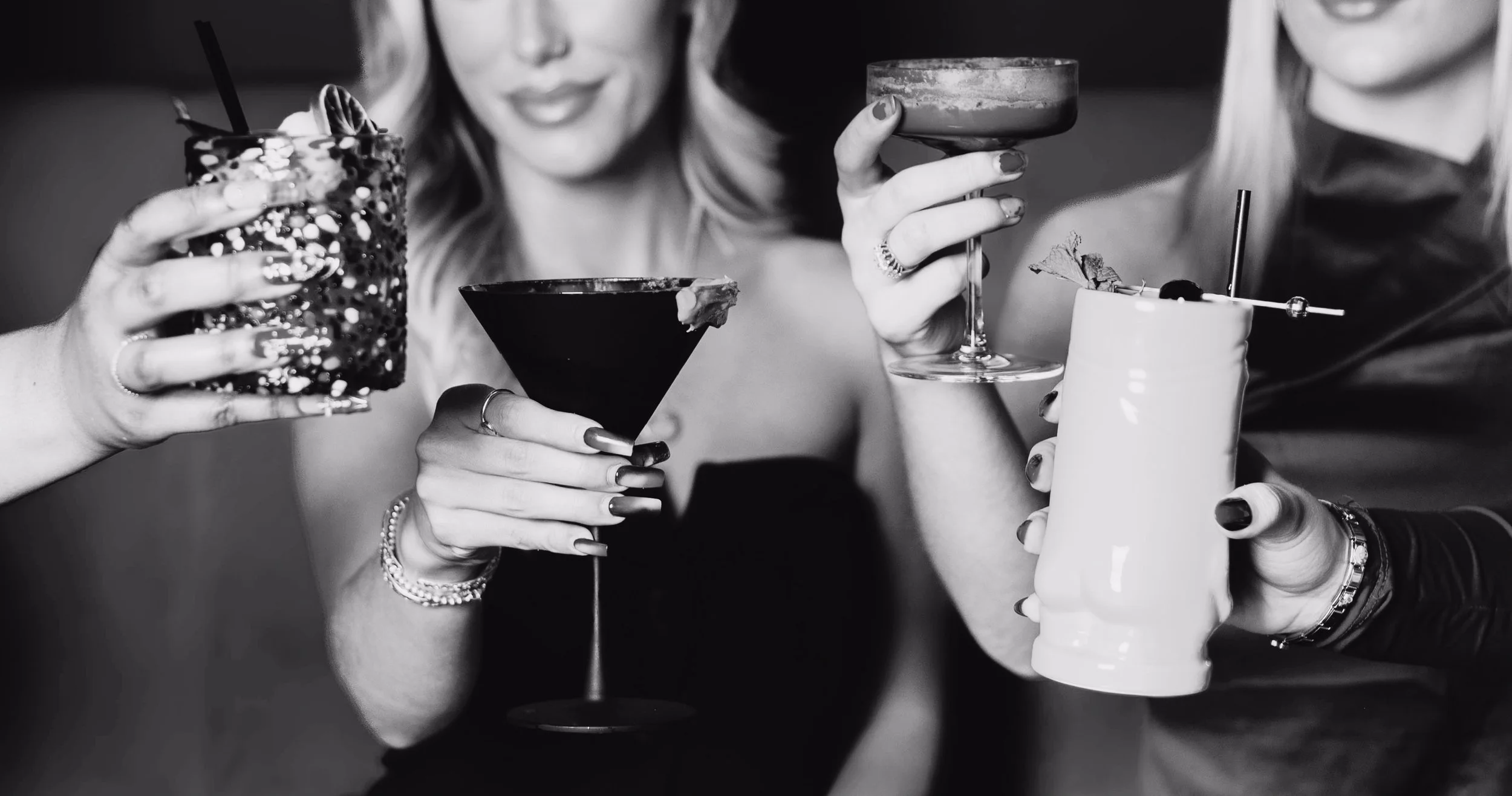 A group of women raising and clinking cocktails together at Silk Utica, capturing the vibrant and social nightlife experience at Utica New York's premier cocktail and dessert bar.