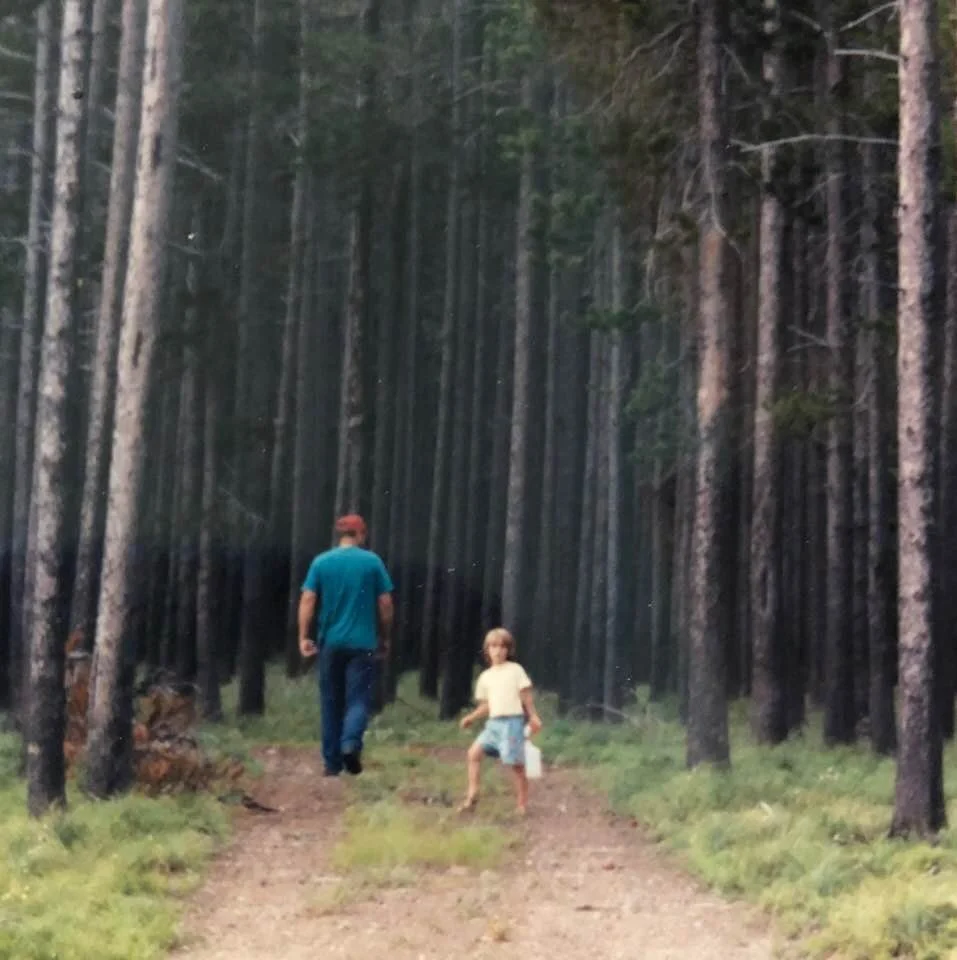 man and child walking in a forest