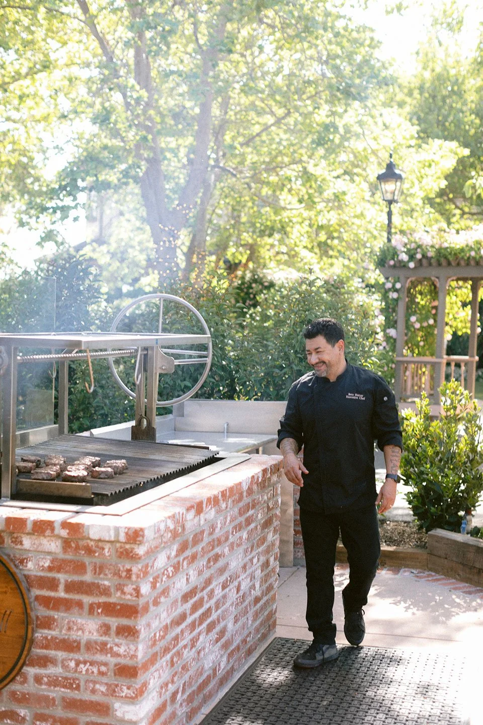 Executive Chef Beto next to our Santa Maria Grill, grilling steaks for an event.
