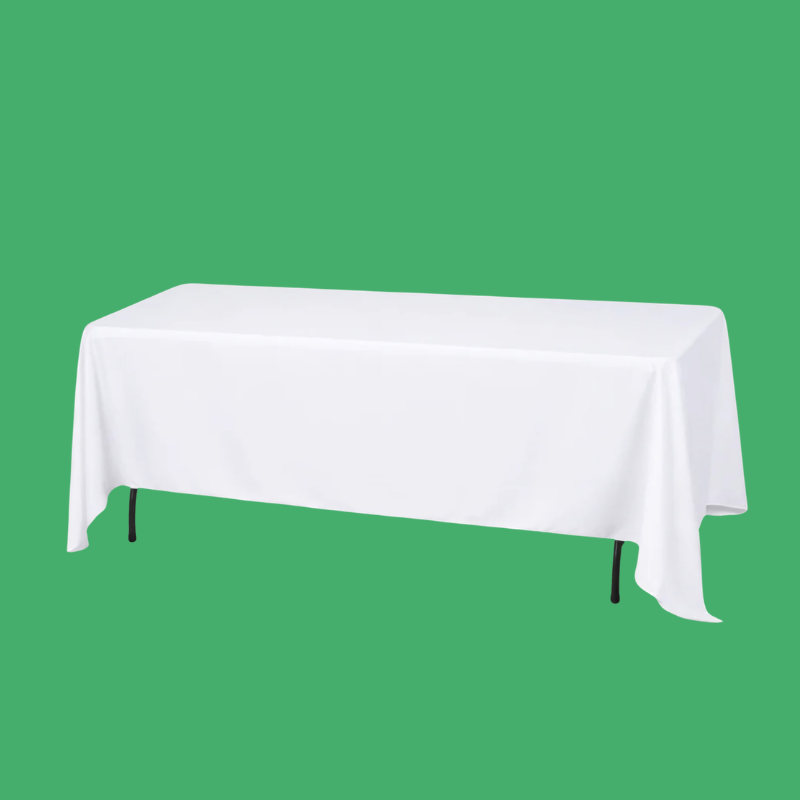 Table covered with a white tablecloth against a green background.