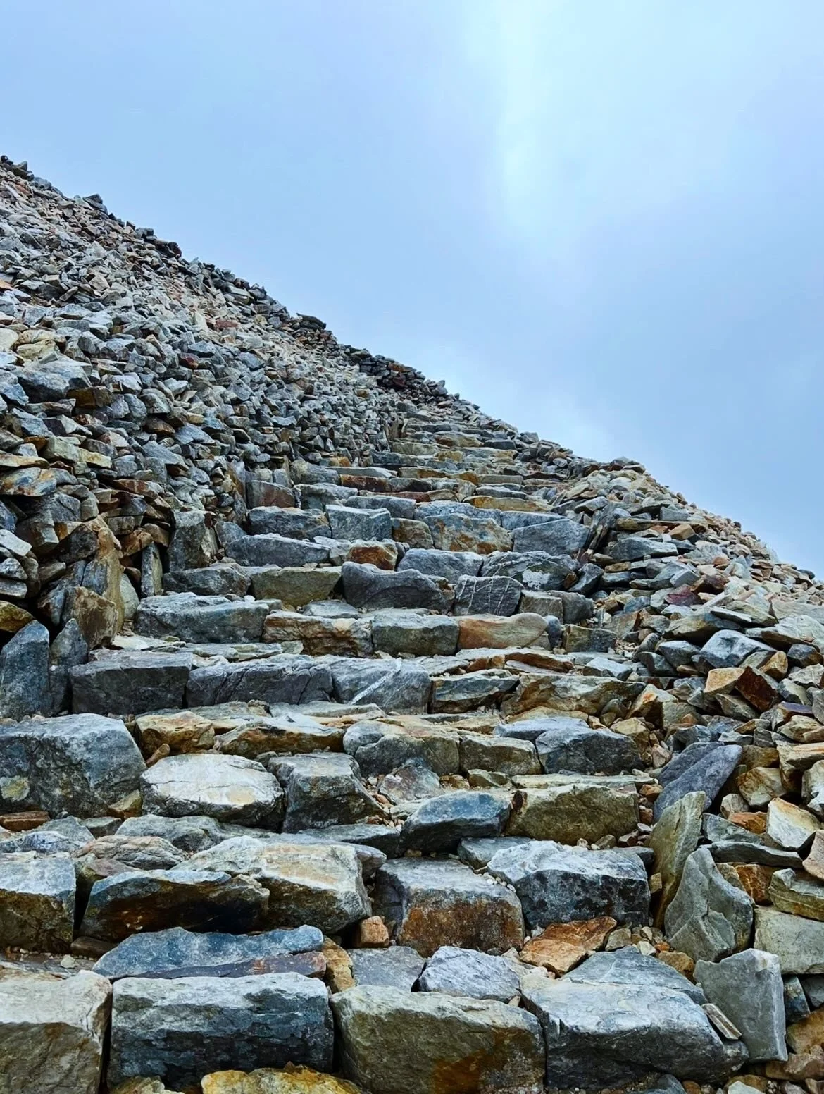 A winding staircase fashioned from large granite blocks.
