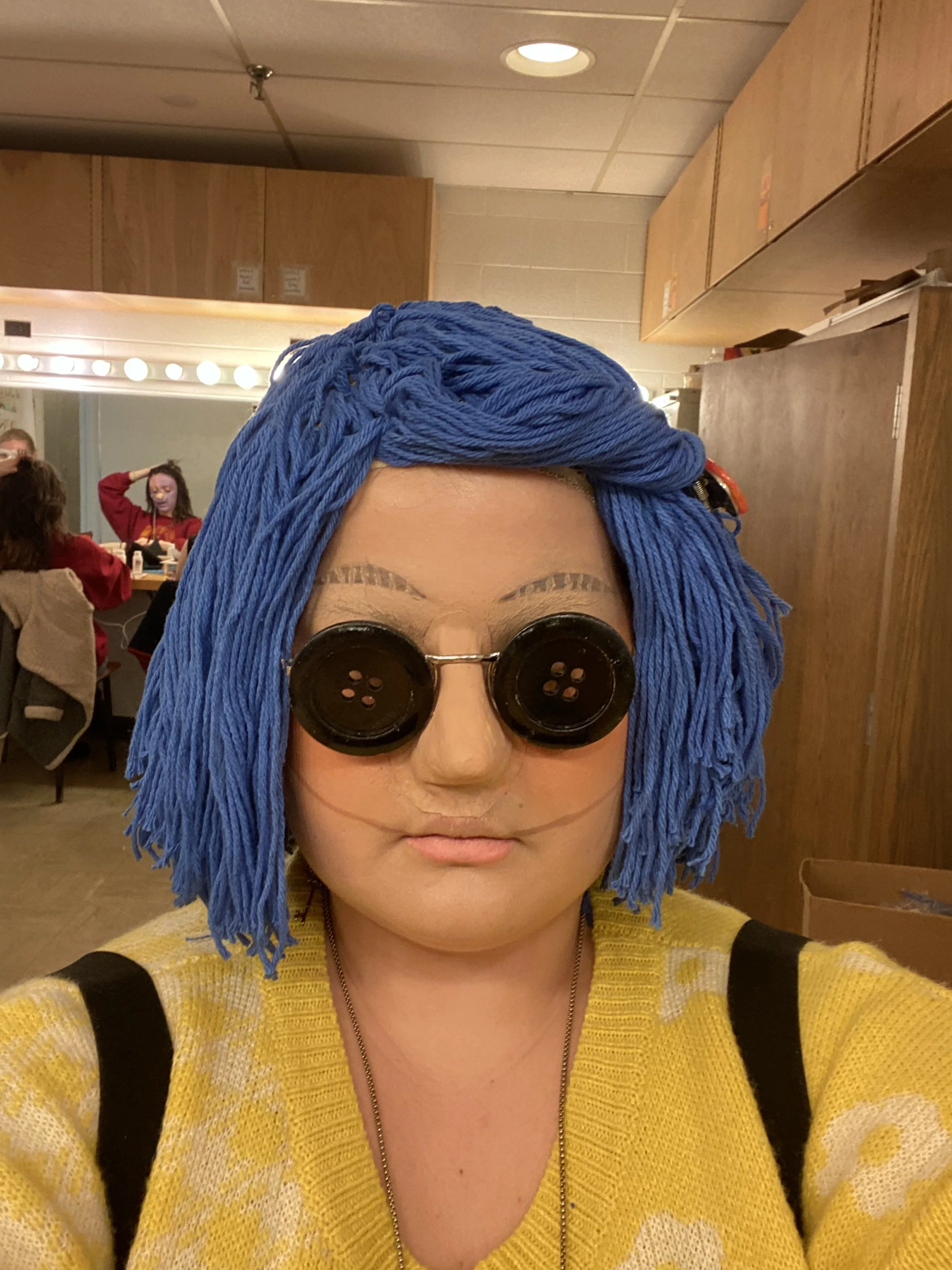Coraline Doll look created with nose prosthetic, yarn wig, button glasses and creme makeup. 