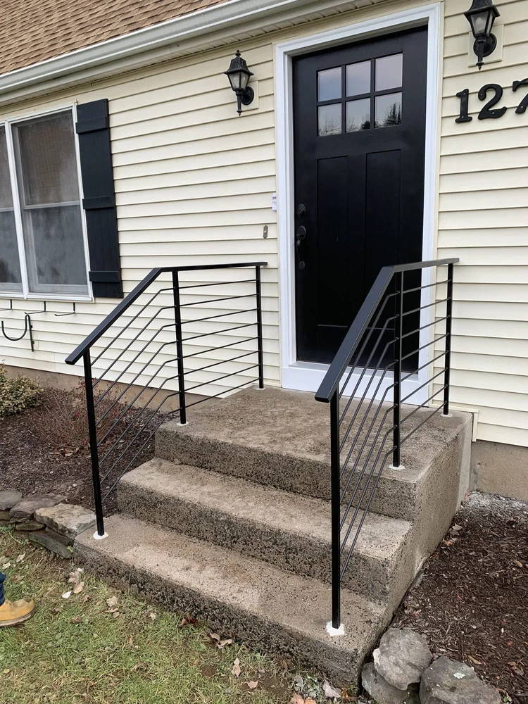 Modern black horizontal-bar railings on concrete front steps
