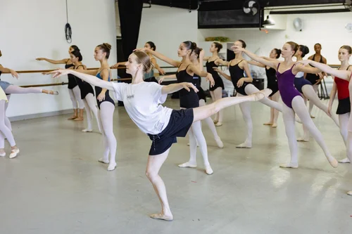 Participants in a free Pointeworks Company Rep Week take ballet class together at the barre