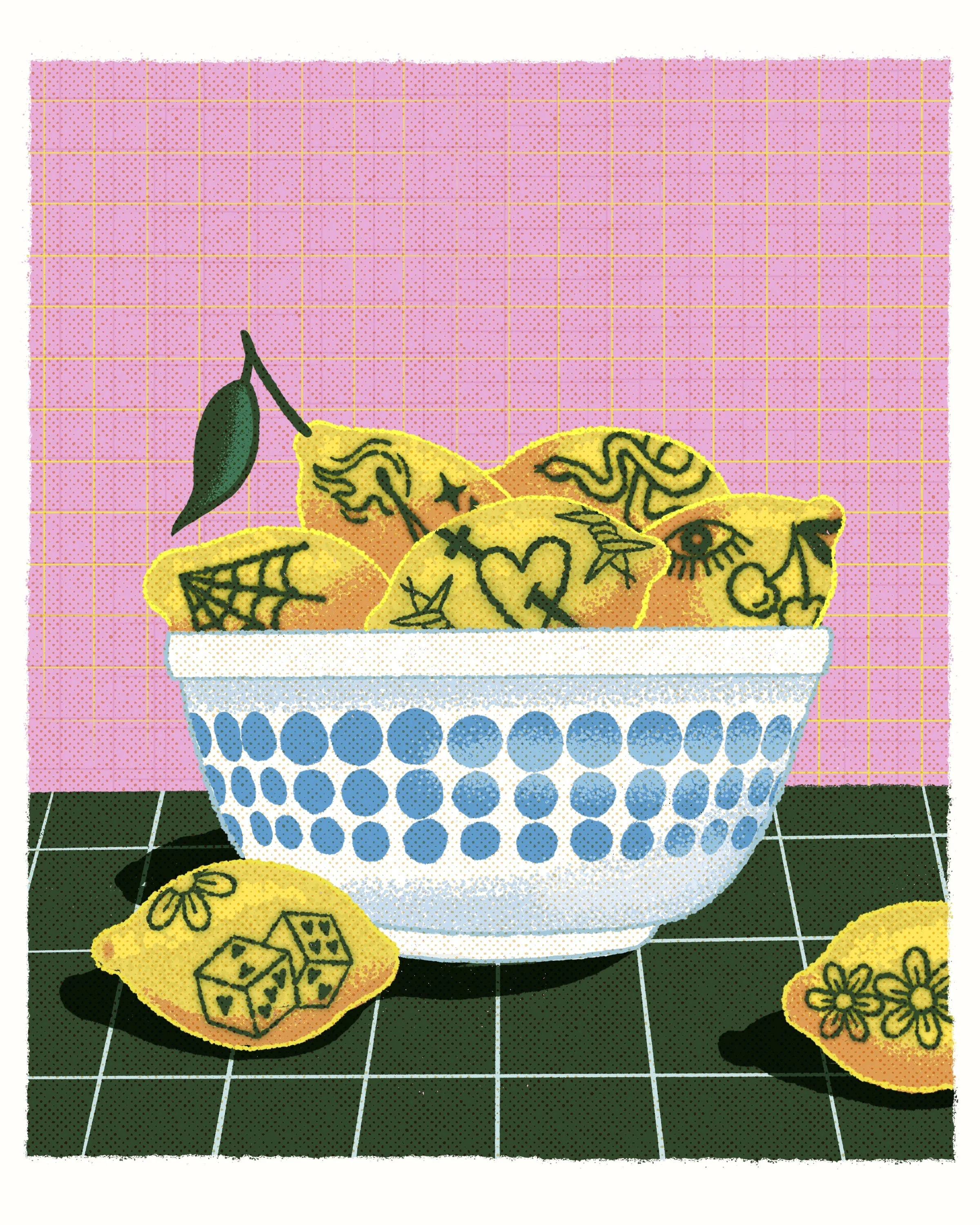 A basket with a blue dotted pattern holds yellow lemons with black tribal-style tattoo designs on their surface. Some lemons are on a black tiled surface with white grout lines, and a few are scattered outside the basket. The background features a pi