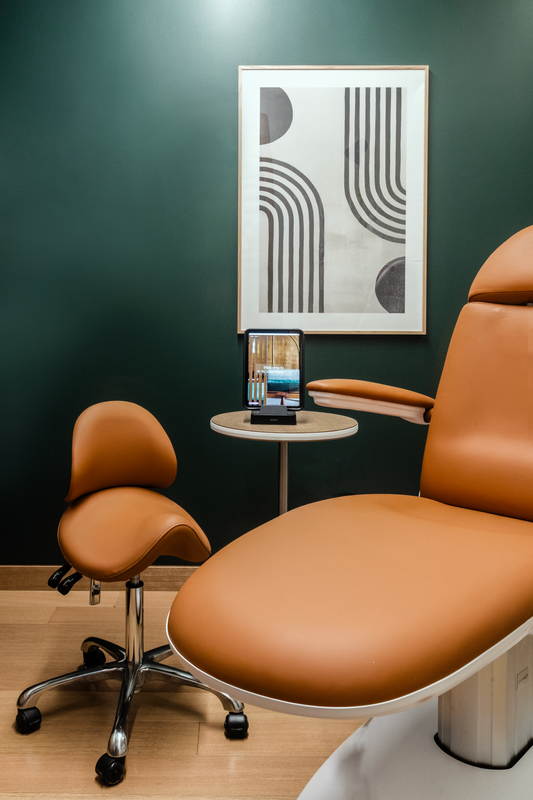 Great Many Atlanta treatment room with camel leather chair upholstery and deep green wall paint.