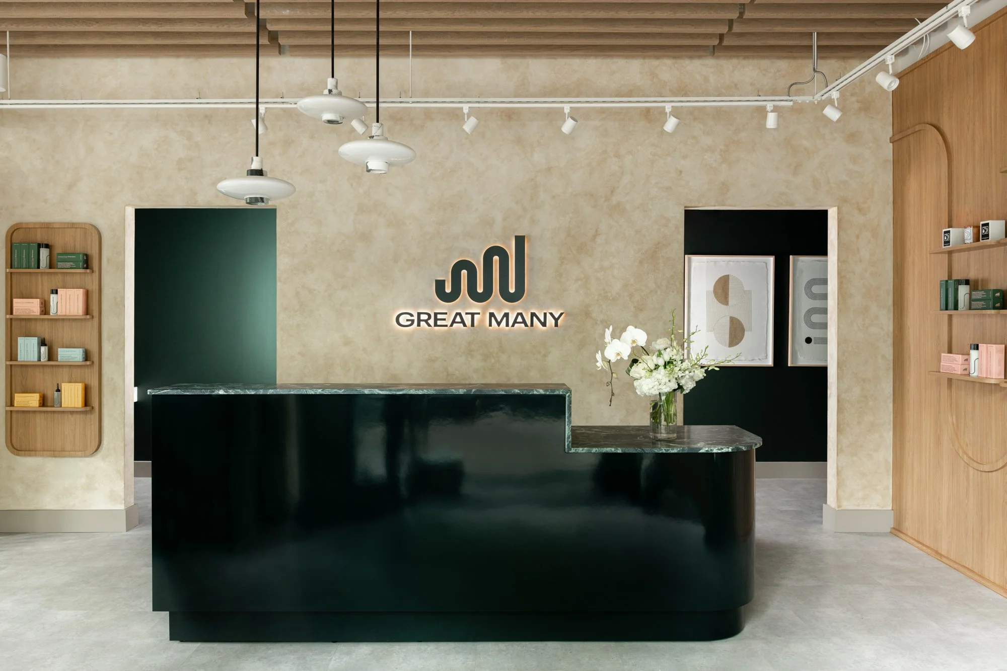 Great Many Washington DC reception space with green desk and countertop in front of a warm french wash wall with custom brand signage