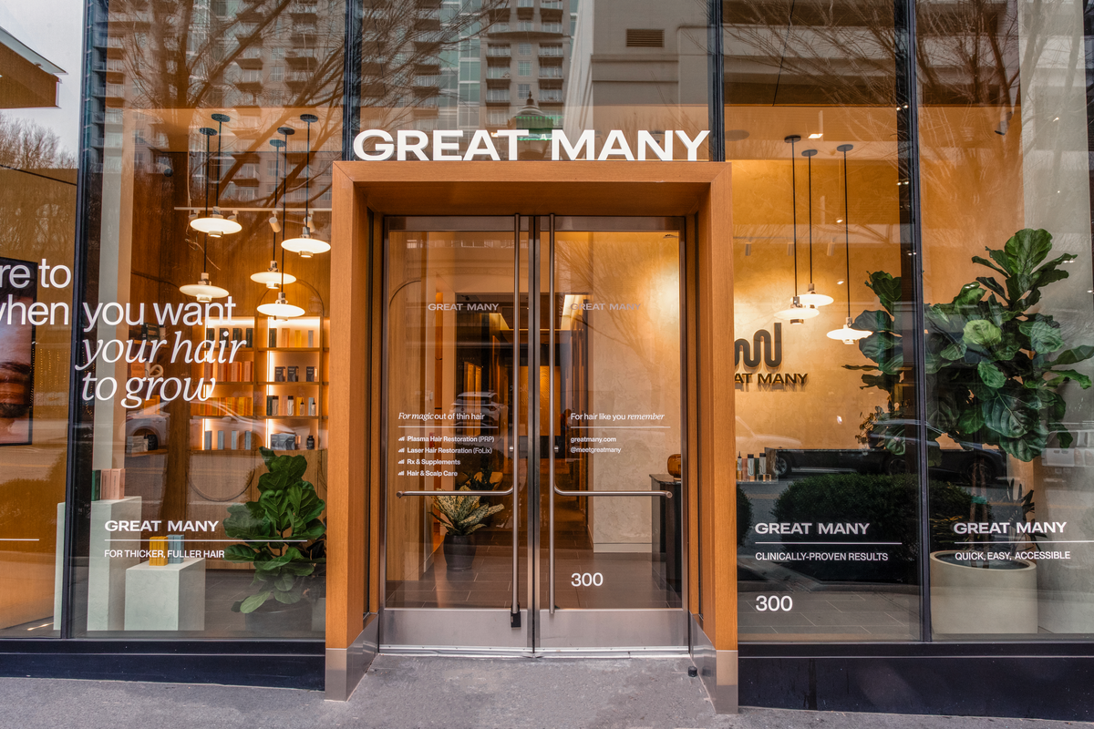 Exterior of Great Many Atlanta. Floor to ceiling windows with vinyl decals invite clients into the hair restoration studio.