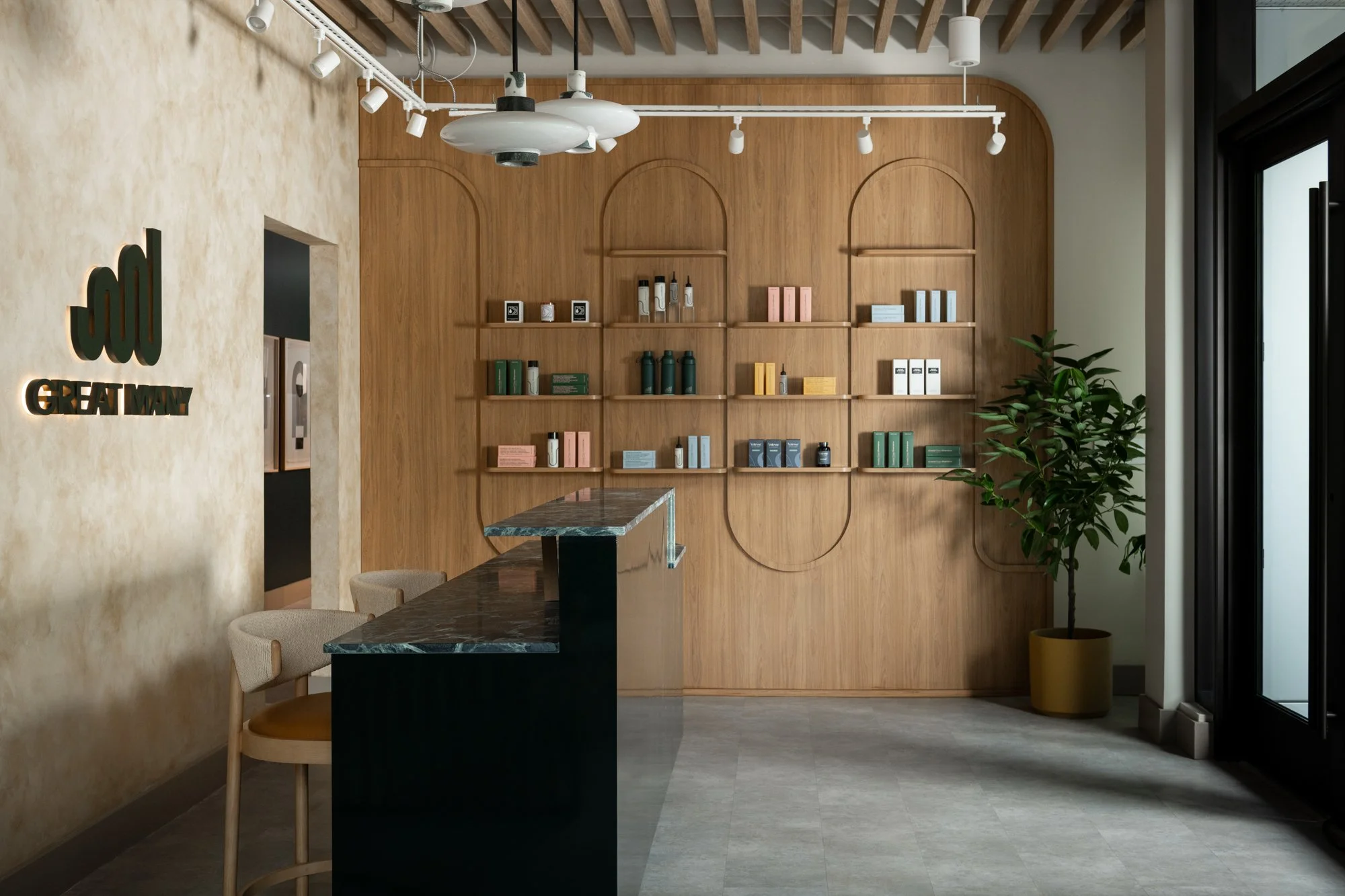 Custom branded retail display shelving at Great Many's Washington DC studio with warm wood and pendant lighting