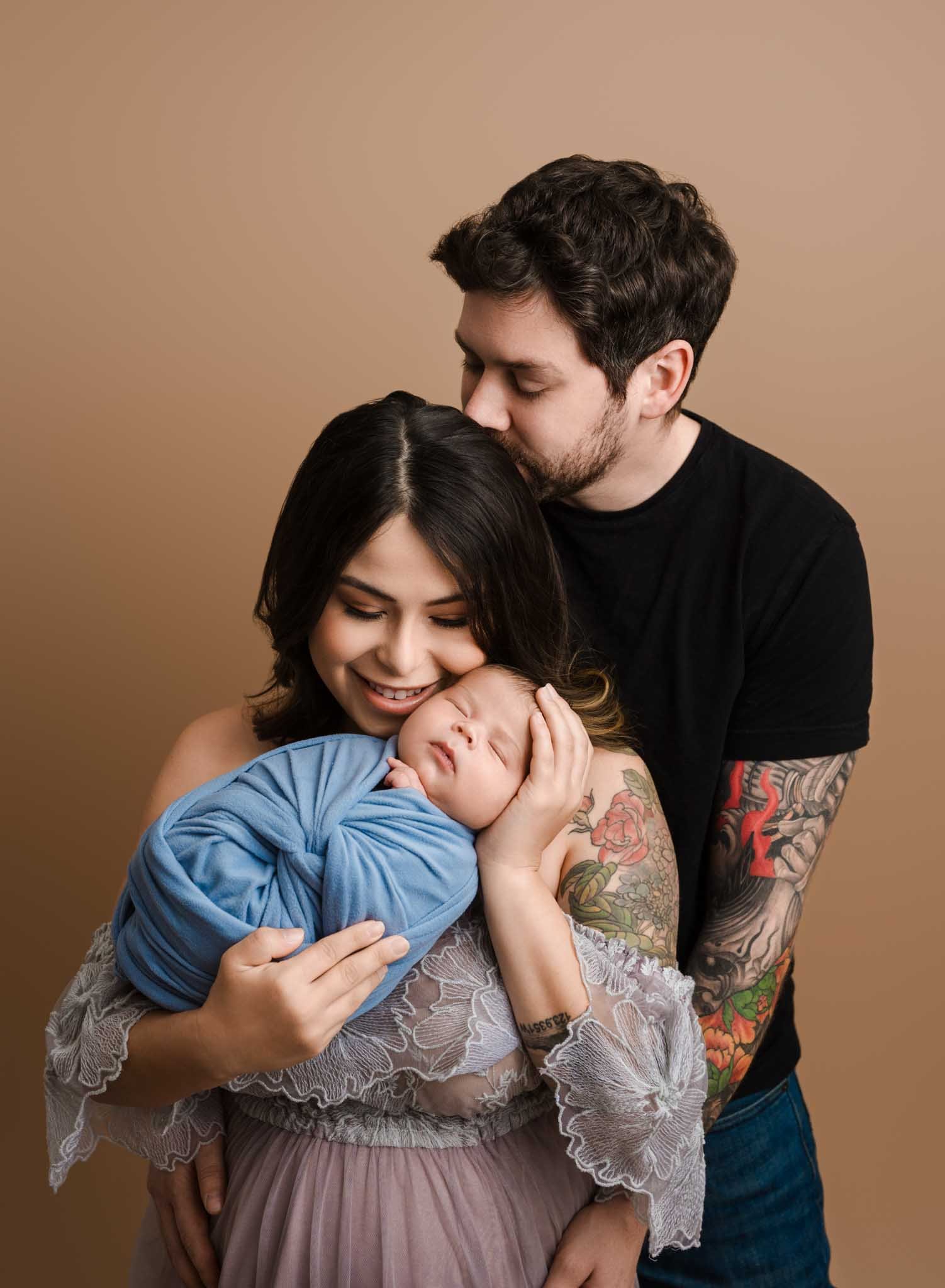 New family hugging and holding newborn baby in Seattle