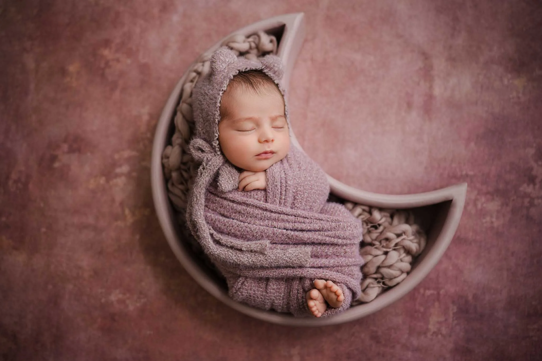 Big sister laying next to newborn baby in Seattle photoshoot