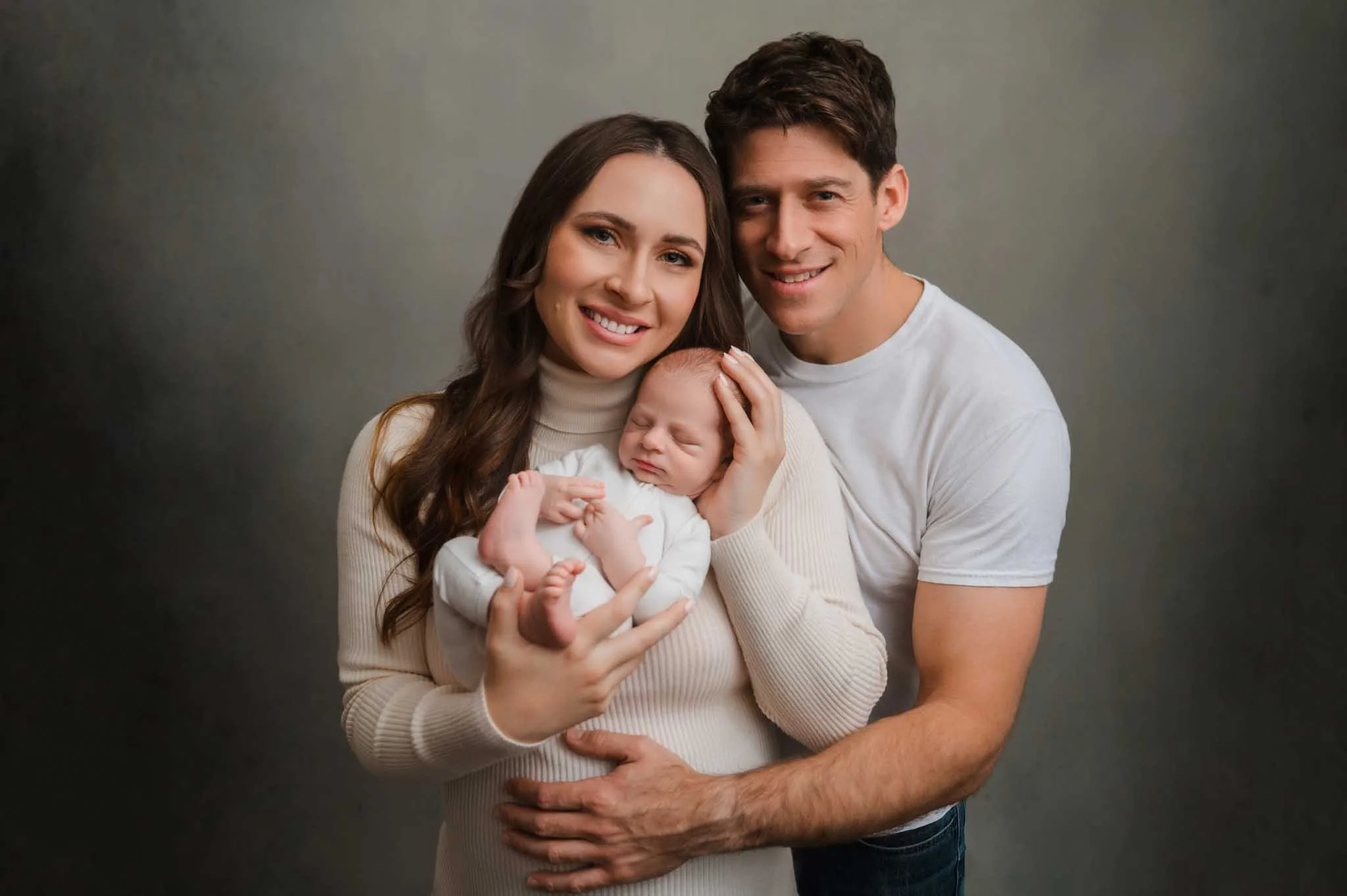 Bellevue couple hugging and holding newborn baby