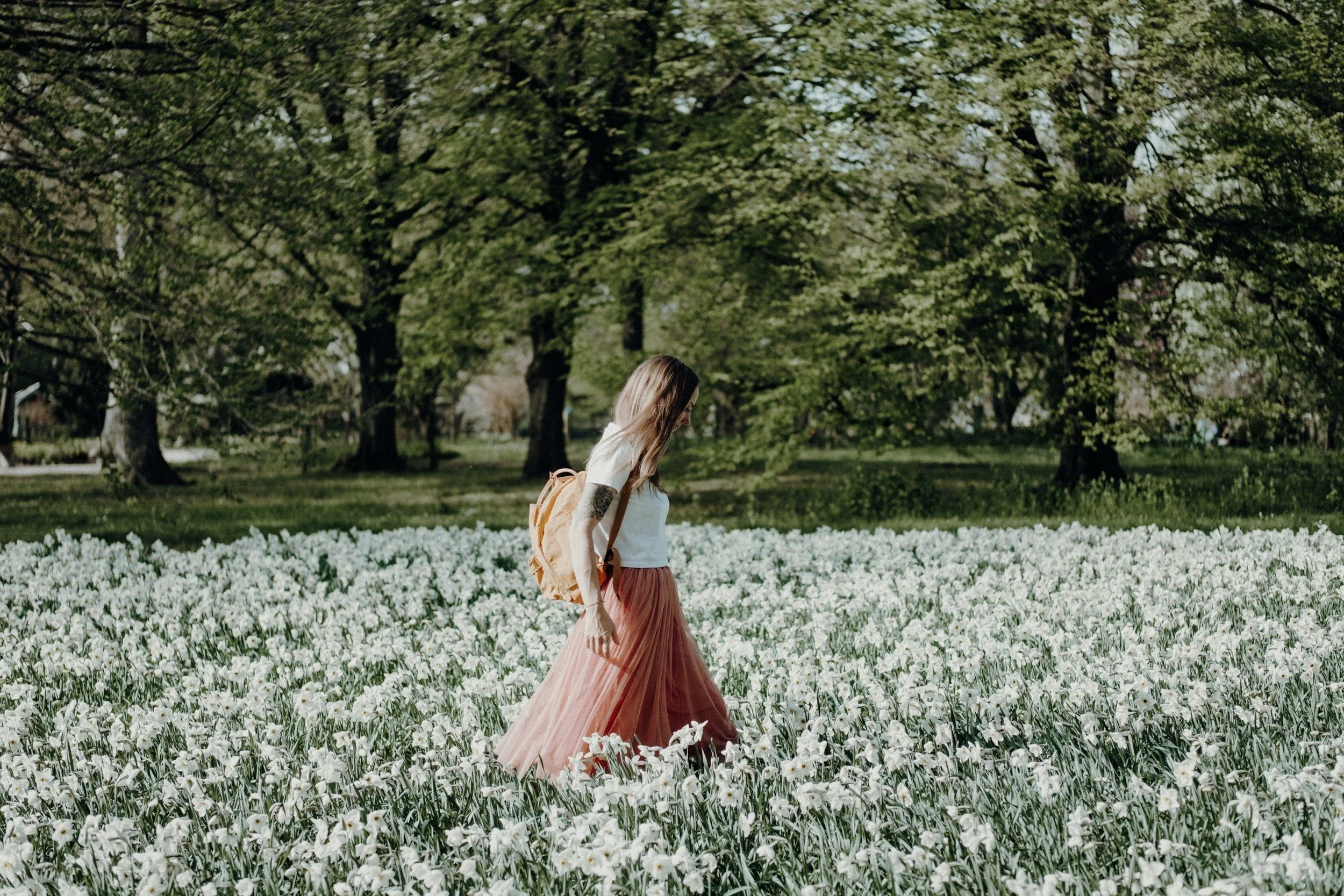woman experiencing infertility taking a reflective walk through a flower field