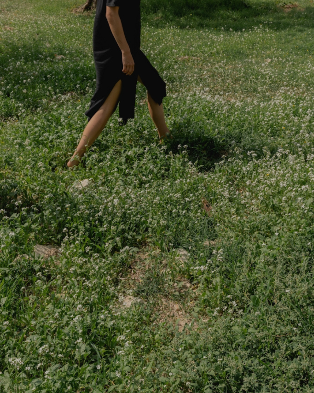a woman who is struggling after infertility treatment is walking through a grass field and trying to feel better