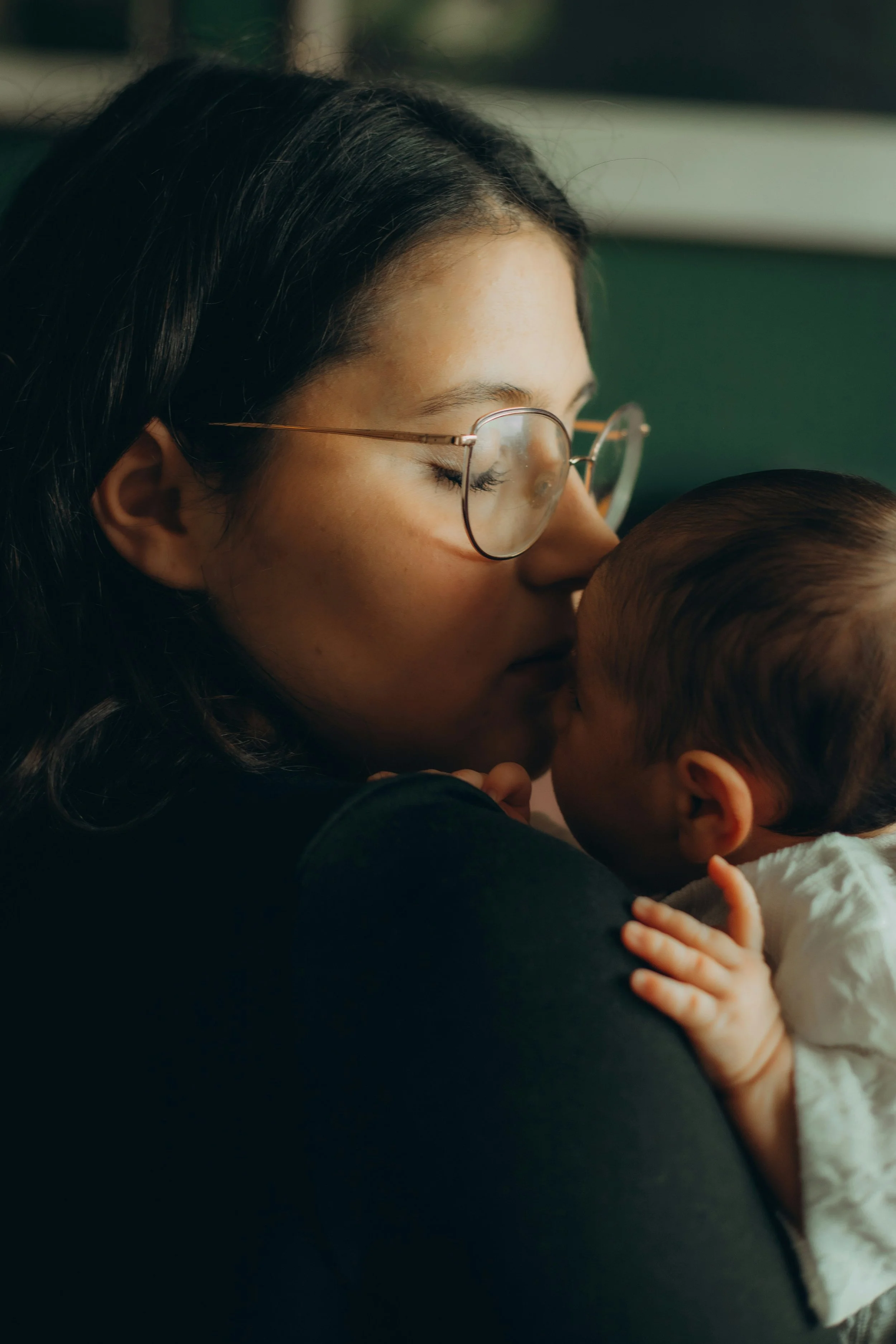 New mom awake at night experiencing postpartum anxiety while her baby sleeps