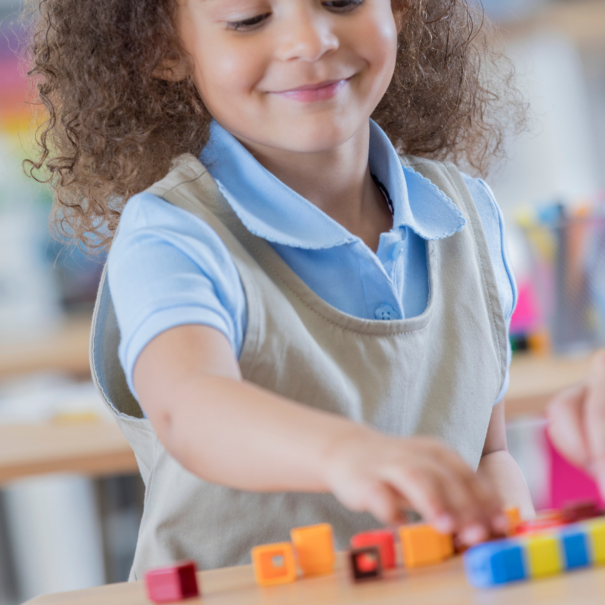 young girl using snap cubes to explore adding and subtracting