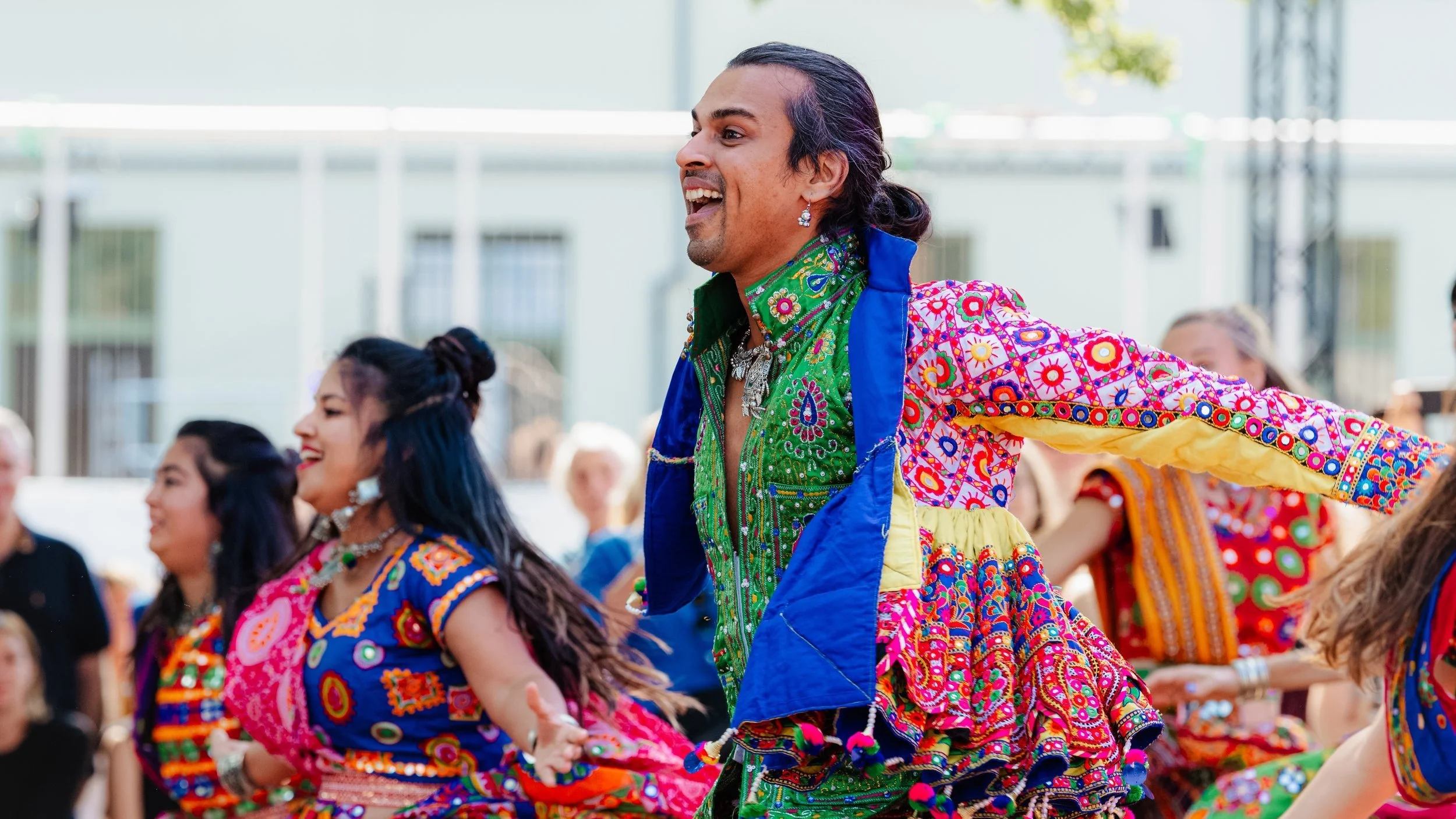 A vibrant group of dancers performing traditional Garba folk dance steps in a lively open-level class at Shoonya Dance Centre in Ghent.