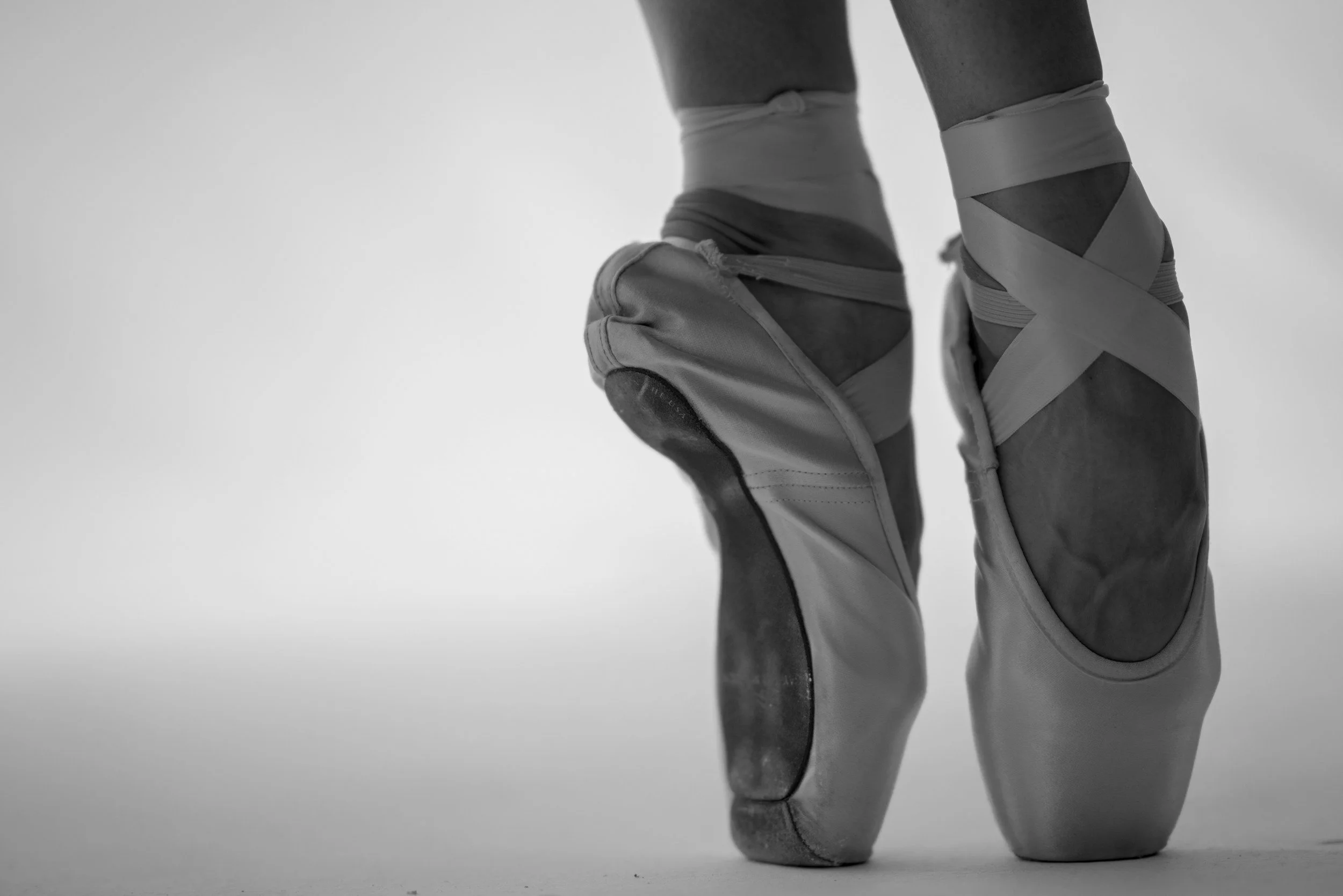 Close-up of a dancer in satin pointe shoes during the Ballet Pointes level class at Shoonya.