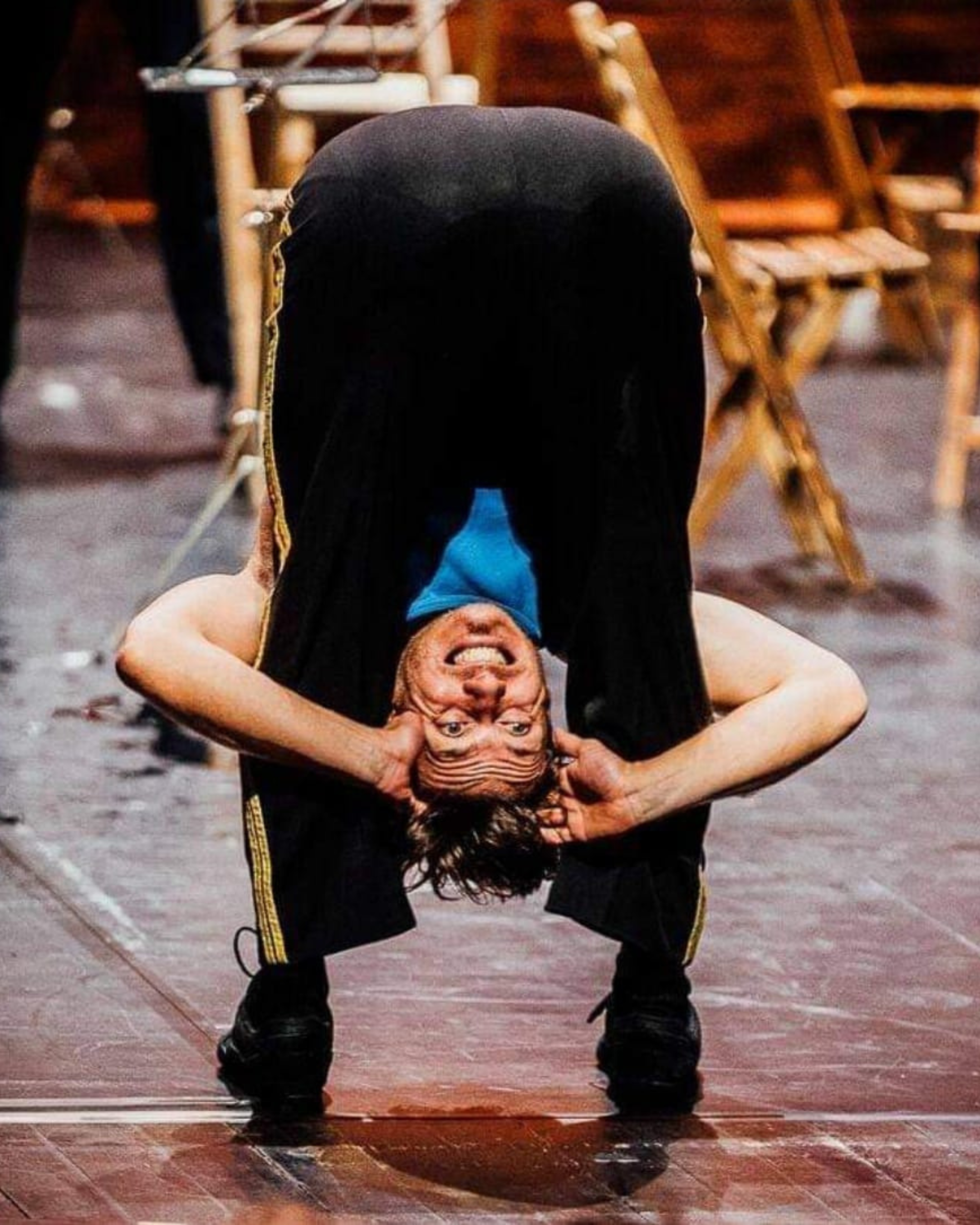 Person dancing in a striped dress against a teal background.