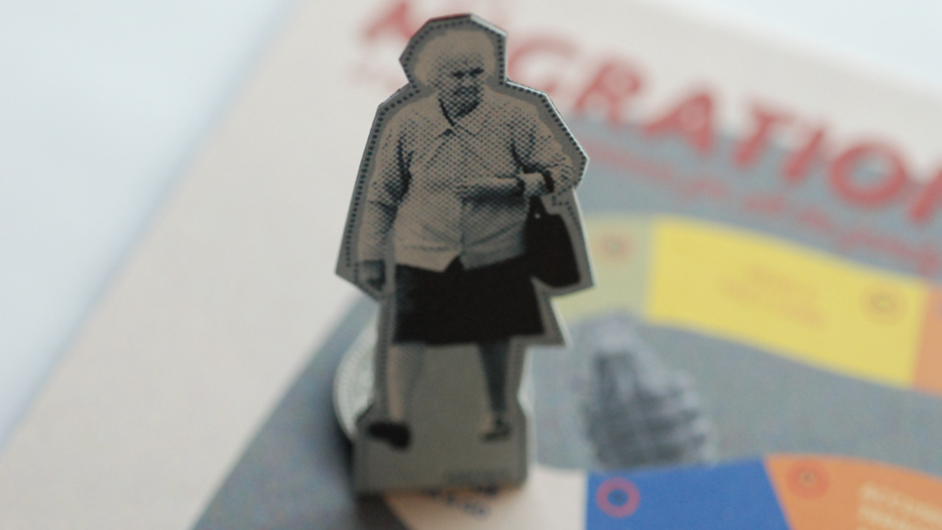 A small, black-and-white sticker depicts a woman walking and holding a bag, with a blurred background of colorful packaging.