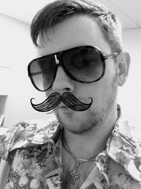 A man wearing large sunglasses, a patterned shirt, and a decorative mustache sticker in a black-and-white photo.