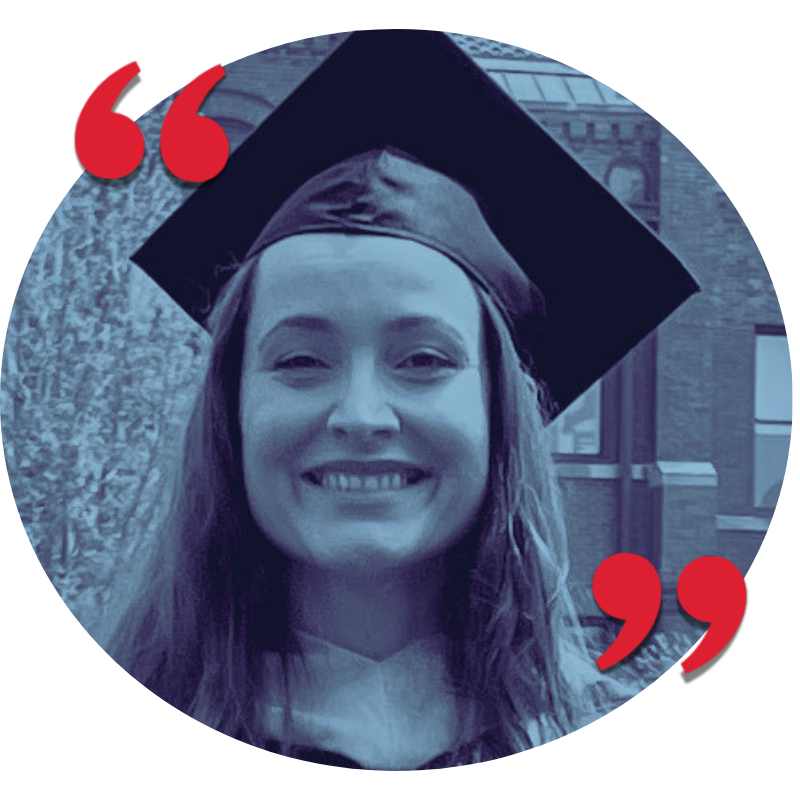 A young woman smiling, wearing a graduation cap and gown, celebrating graduation outdoors.