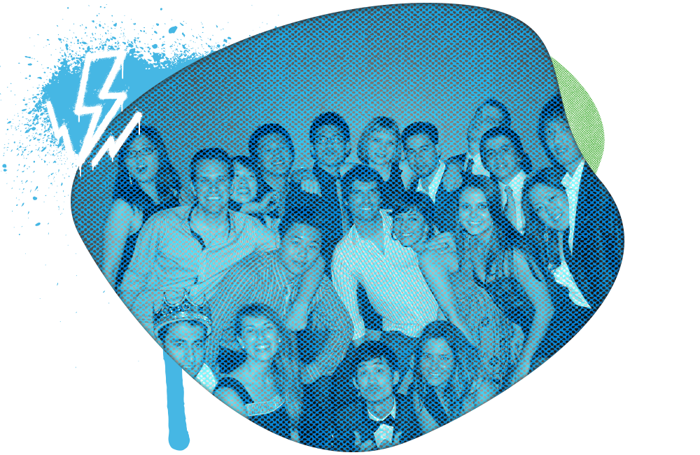 A group of people having a party, some wearing crowns, with numbered badges, inside a large electric guitar shape with a lightning bolt and splash effects.