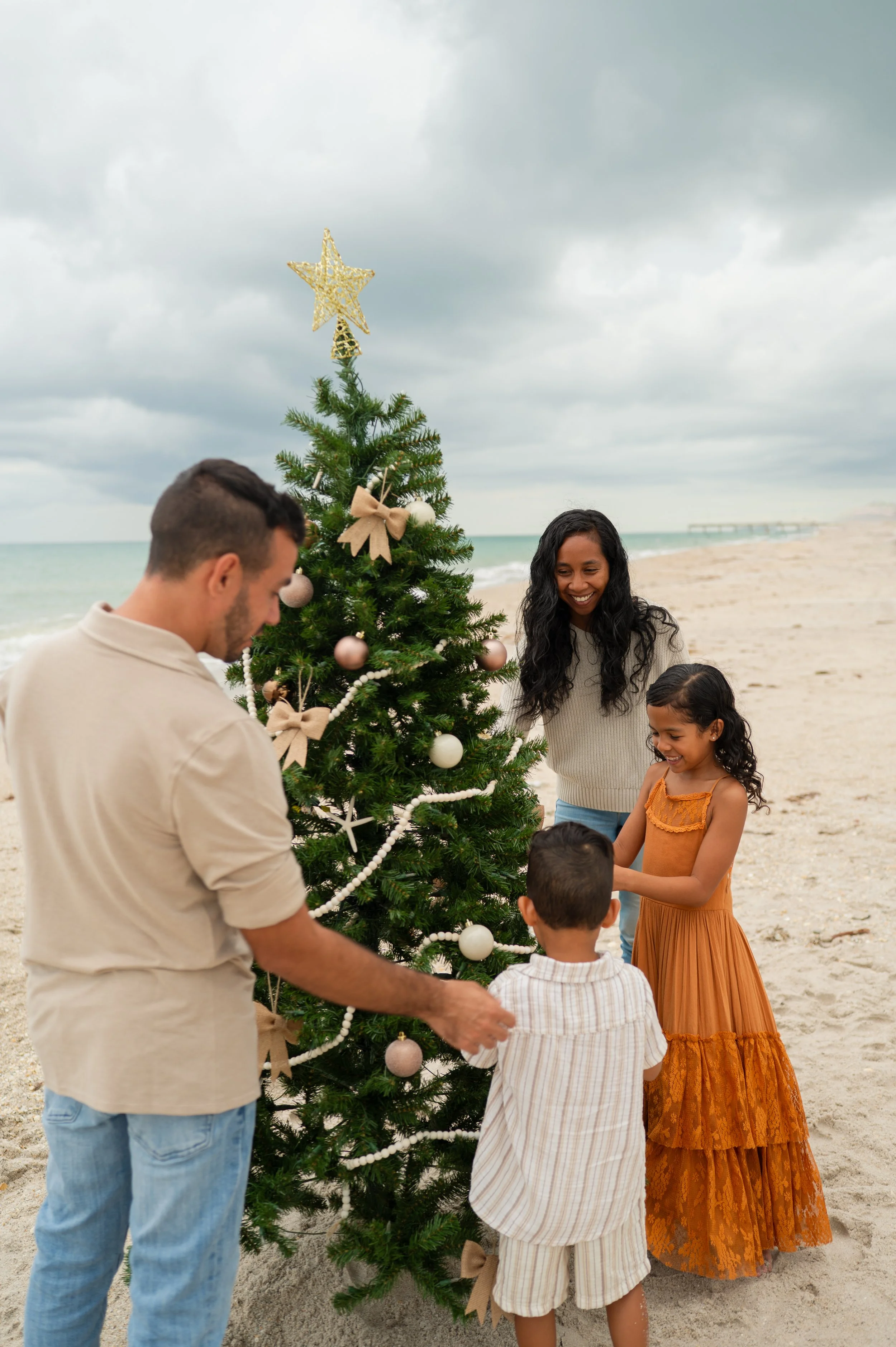 Family gathered around Christmas tree at the beach