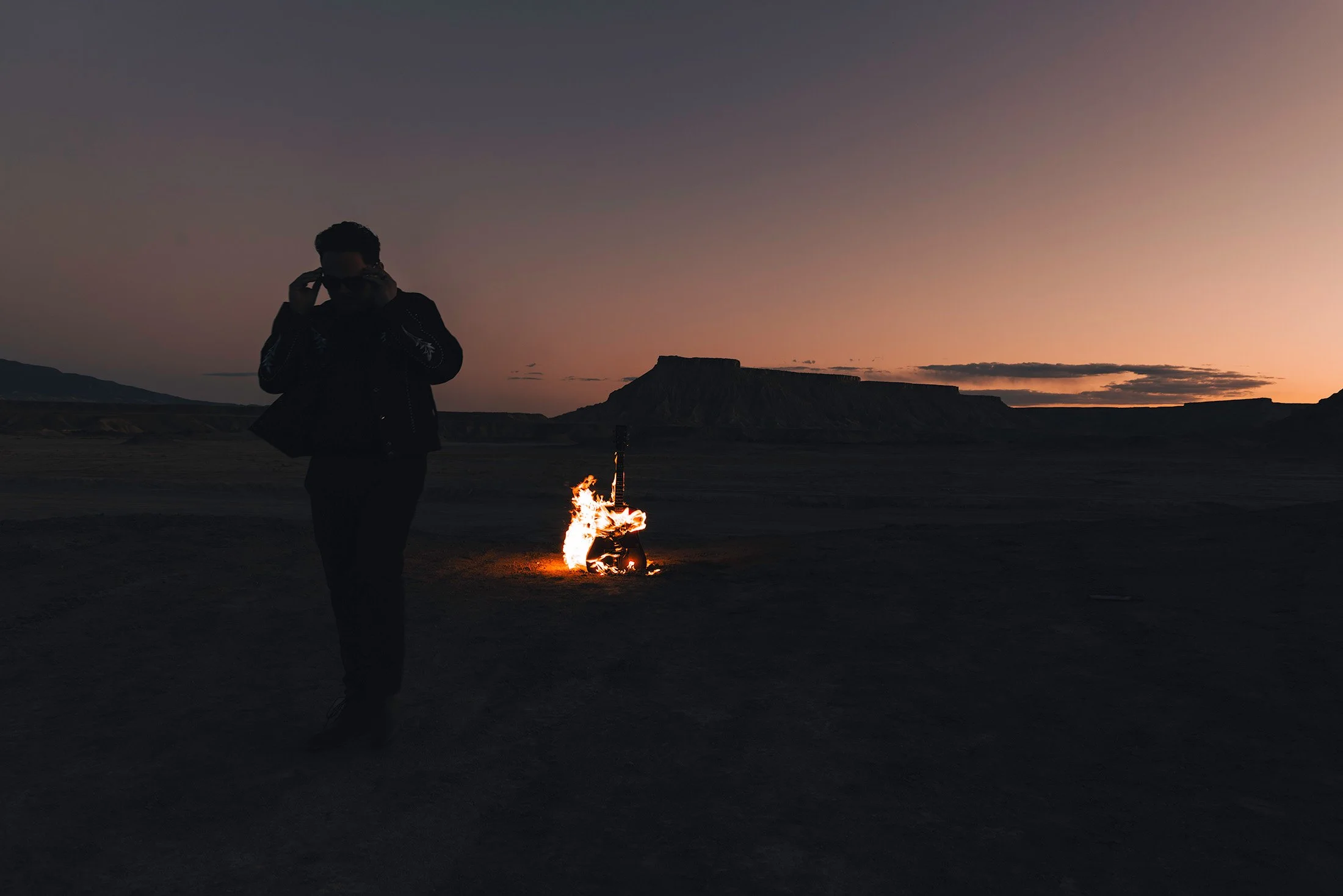Wyatt Lowe Walking away from guitar on fire in desert